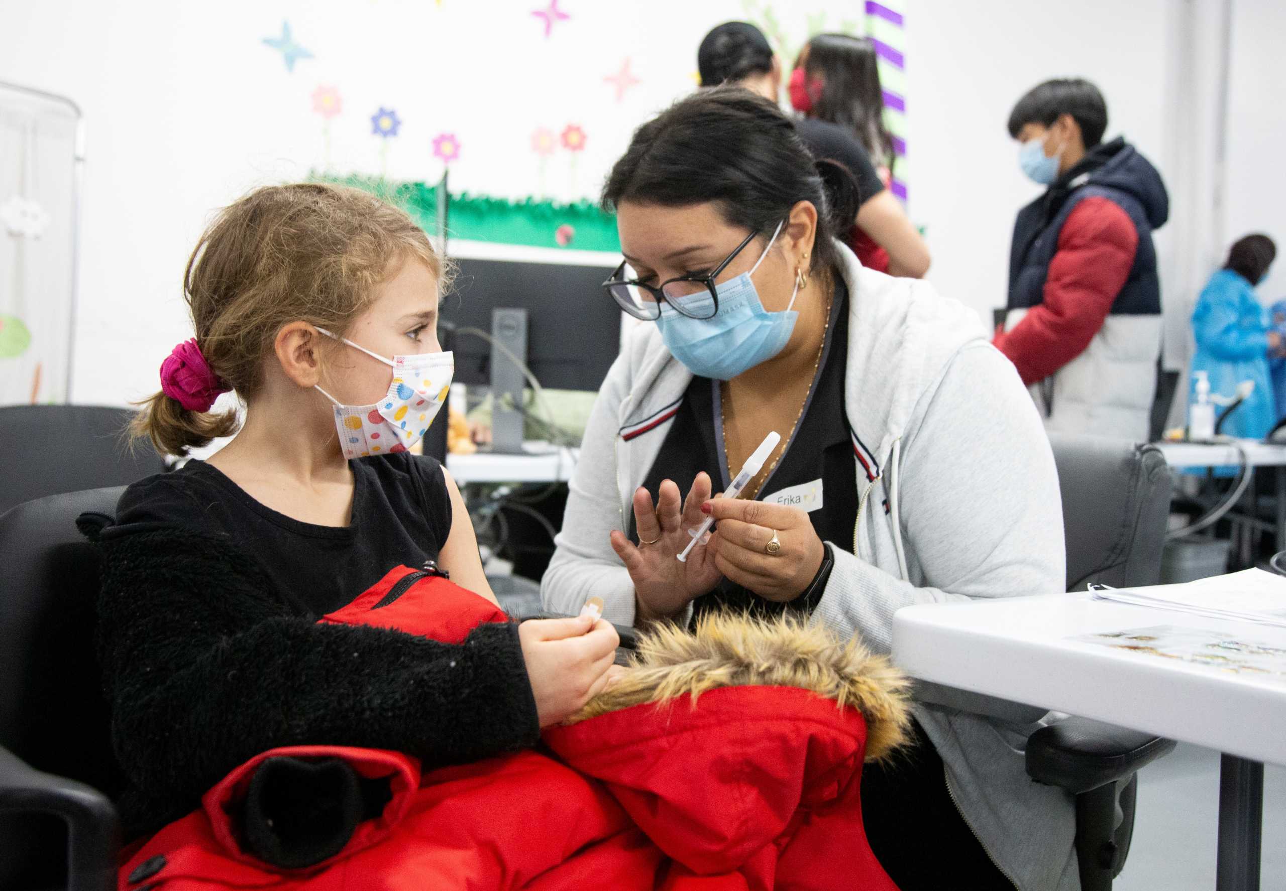 Nine-year-old Vivien Murphy is shown the needle prior to her shot at a vaccination clinic after Canada approved Pfizer's coronavirus disease (COVID-19) vaccine for children aged 5 to 11, in Montreal, Quebec, Canada November 26, 2021.  REUTERS