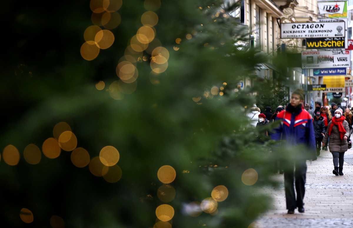 Christmas lights illuminate a tree as people walk along a shopping street after the fourth full national coronavirus disease (COVID-19) lockdown lifted, in Vienna, Austria, December 13, 2021. REUTERS