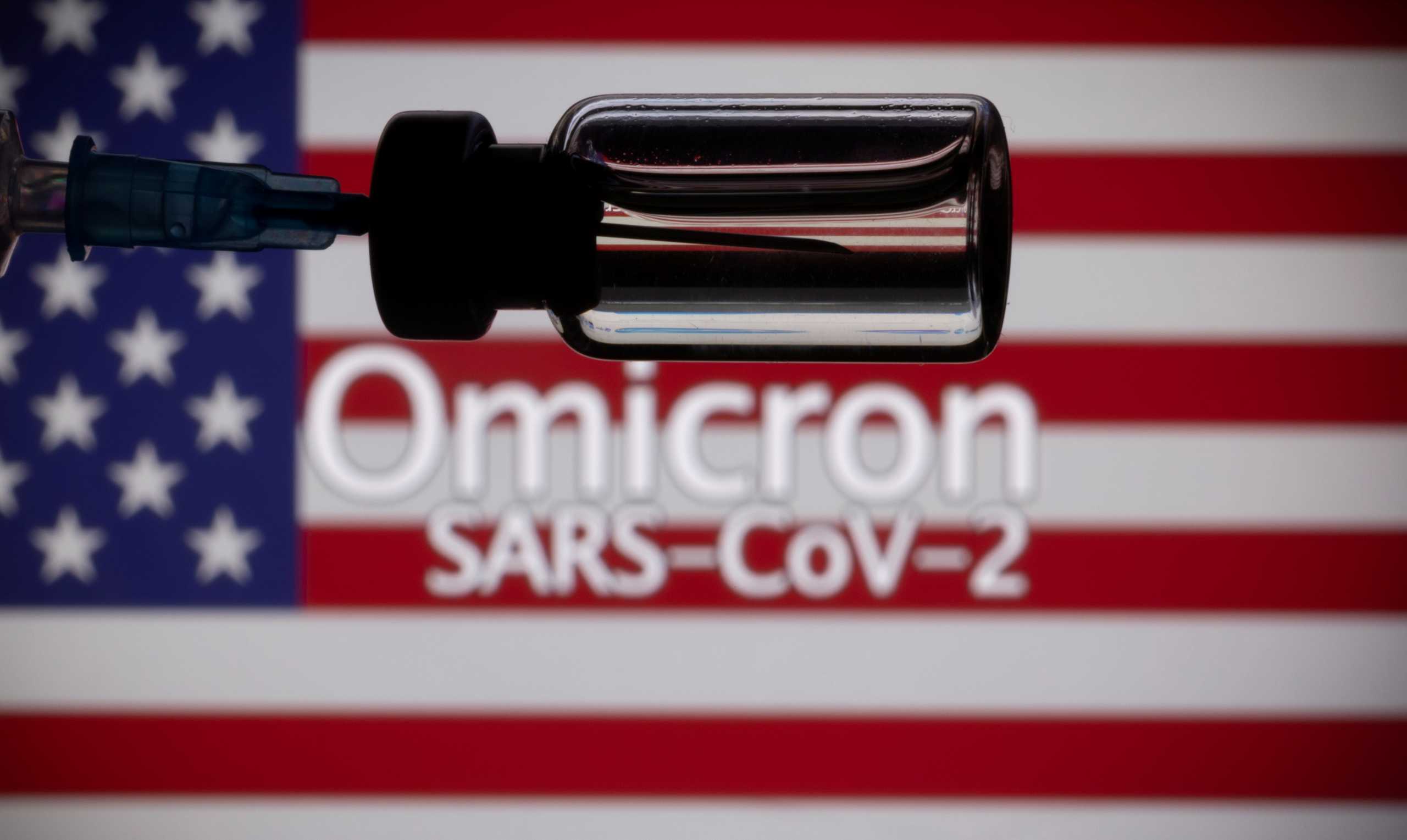 FILE PHOTO: A vial and a syringe are seen in front of a displayed United States' flag and words "Omicron SARS-CoV-2" in this illustration taken, November 27, 2021. REUTERS