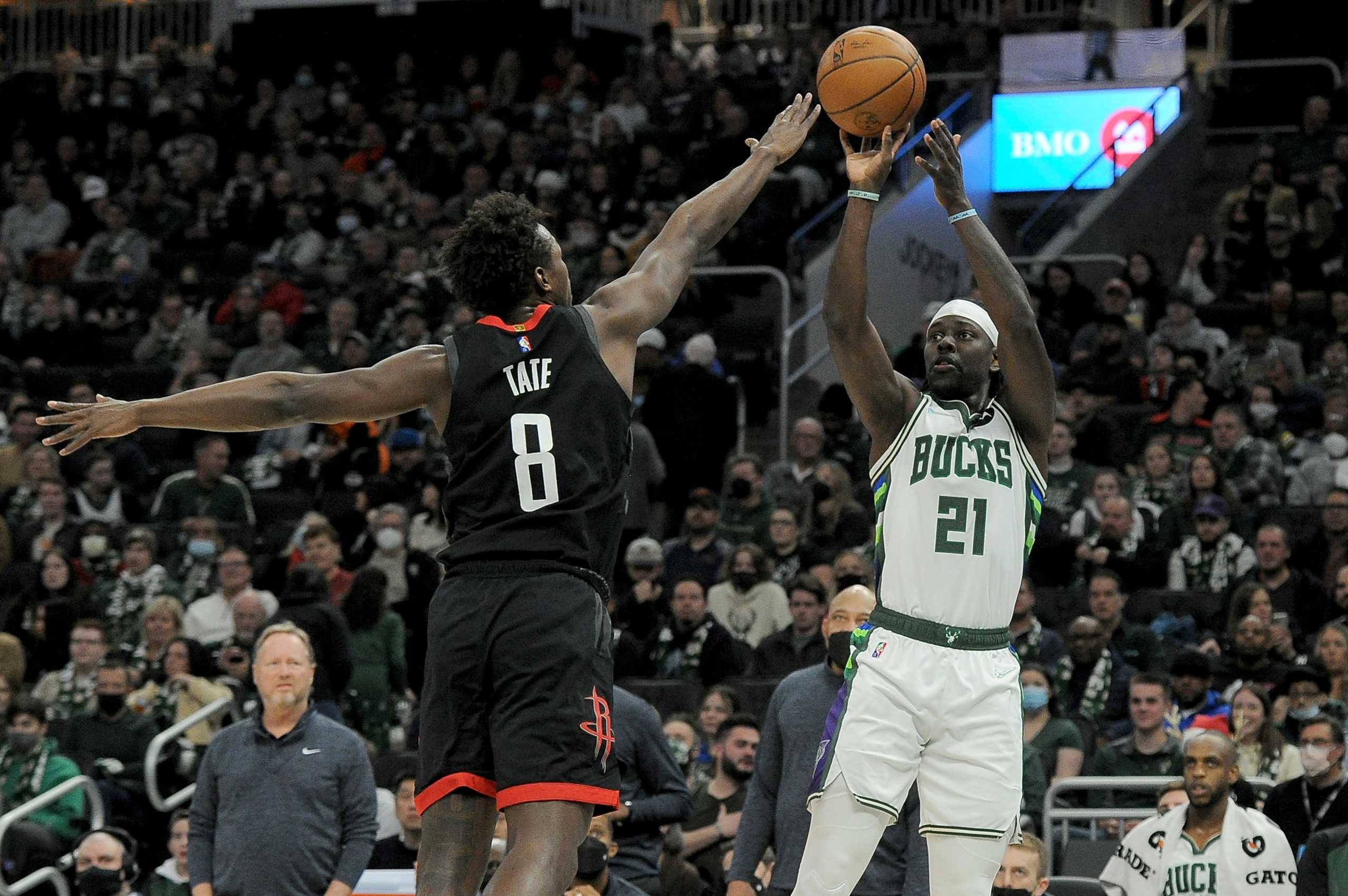 Dec 22, 2021; Milwaukee, Wisconsin, USA;  Milwaukee Bucks guard Jrue Holiday (21) puts up a shot against Houston Rockets forward Jae'Sean Tate (8) in the first half at Fiserv Forum. Mandatory Credit: Michael McLoone-USA TODAY Sports