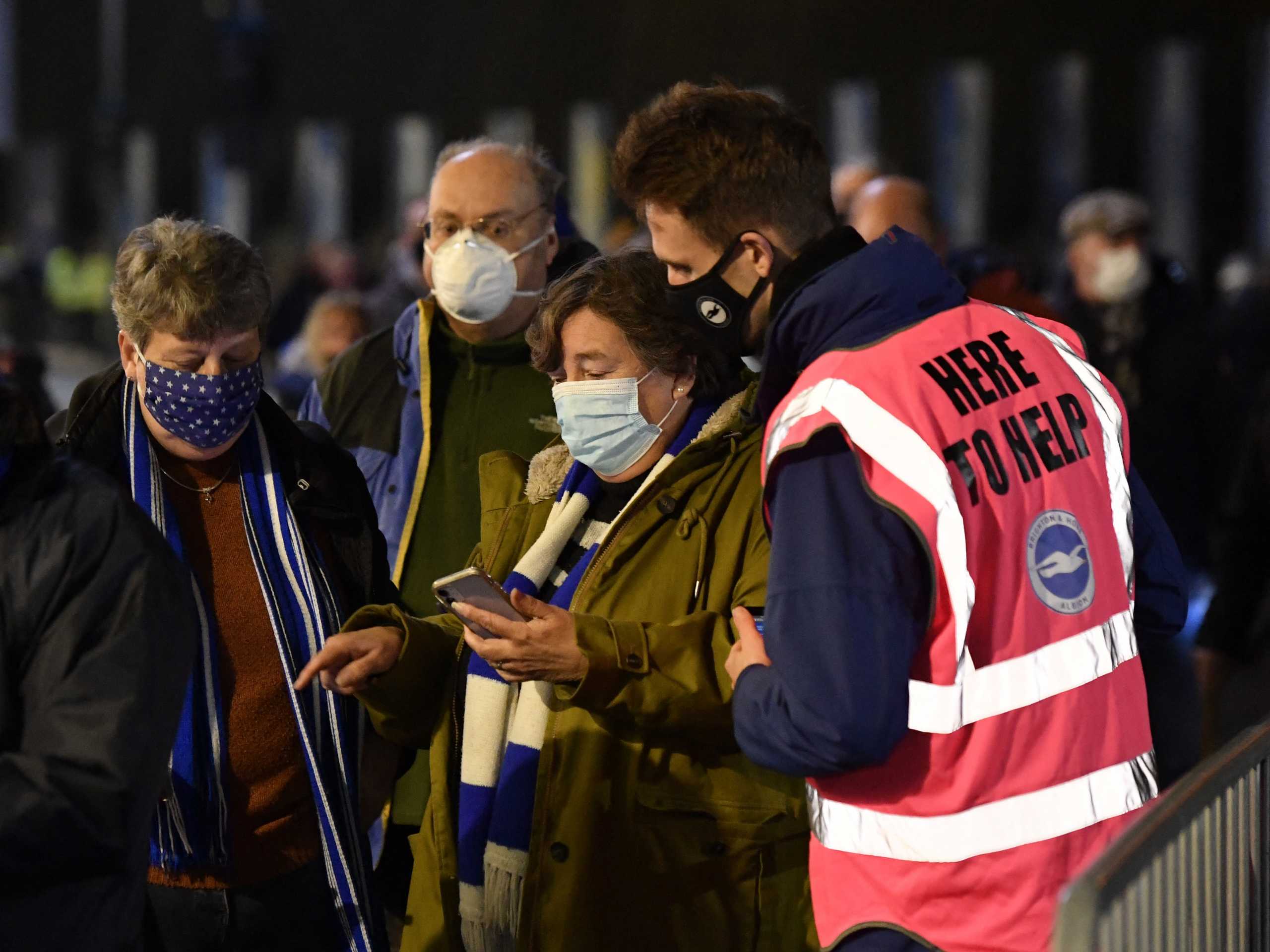 Soccer Football - Premier League - Brighton & Hove Albion v Wolverhampton Wanderers - The American Express Community Stadium, Brighton, Britain - December 15, 2021  Fan gets coronavirus disease (COVID-19) pass checked outside the stadium before the match REUTERS