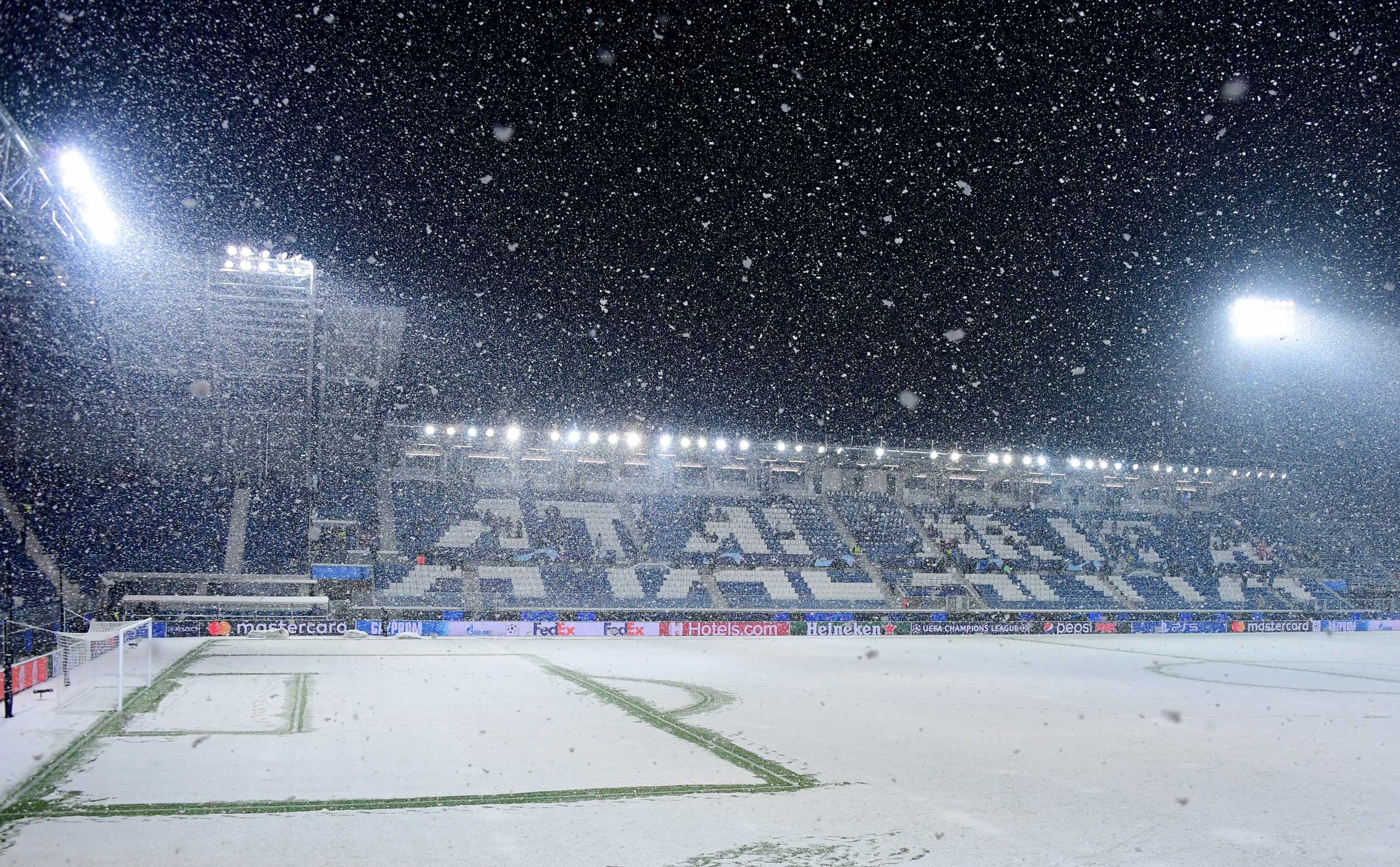 Soccer Football - Champions League - Group F - Atalanta v Villarreal - Stadio Atleti Azzurri, Bergamo, Italy - December 8, 2021 Staff clears the lines of the pitch before the match during a snowfall REUTERS