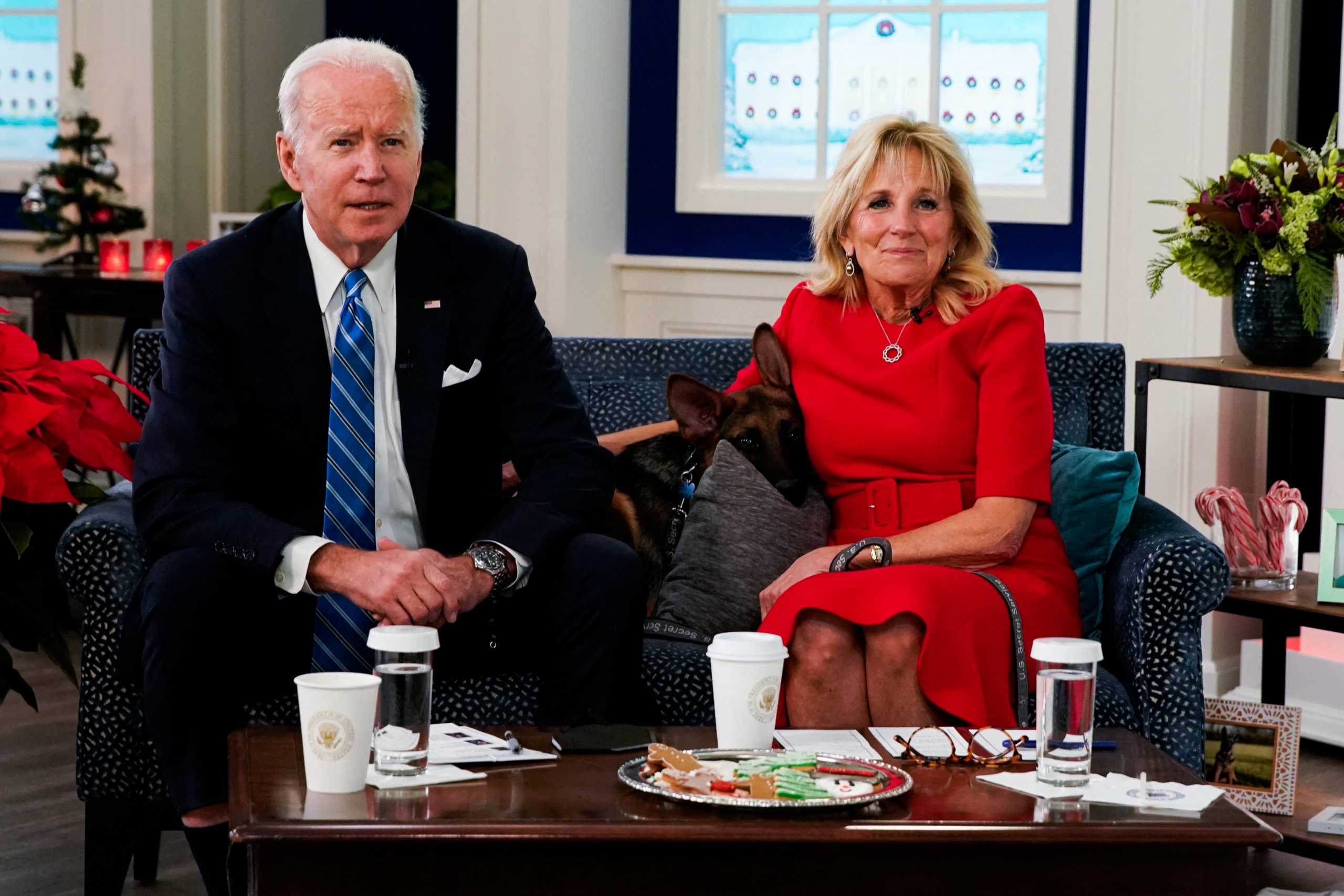 Commander, the Biden family's new puppy, is seen with U.S. President Joe Biden and first lady Jill Biden as they meet virtually with service members in the Eisenhower Executive Office Building's South Court Auditorium at the White House, in Washington, U.S., December 25, 2021. REUTERS