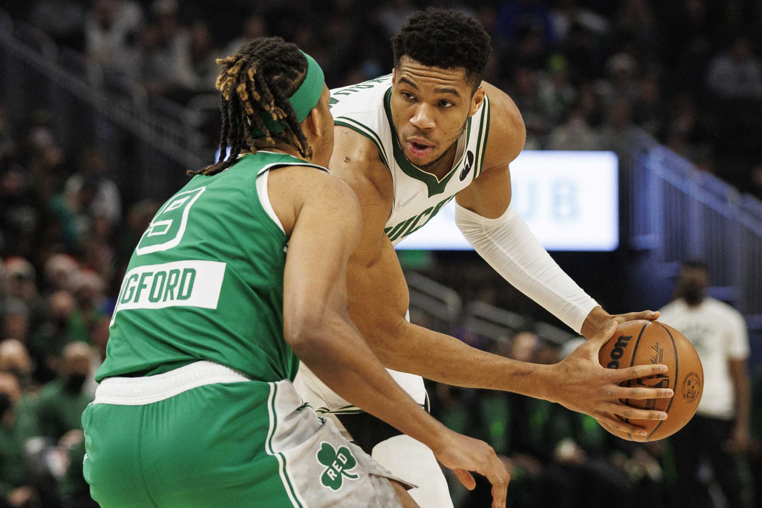 Dec 25, 2021; Milwaukee, Wisconsin, USA;  Milwaukee Bucks forward Giannis Antetokounmpo (34) holds the ball away from Boston Celtics guard Romeo Langford (9) during the first quarter at Fiserv Forum. Mandatory Credit: Jeff Hanisch-USA TODAY Sports