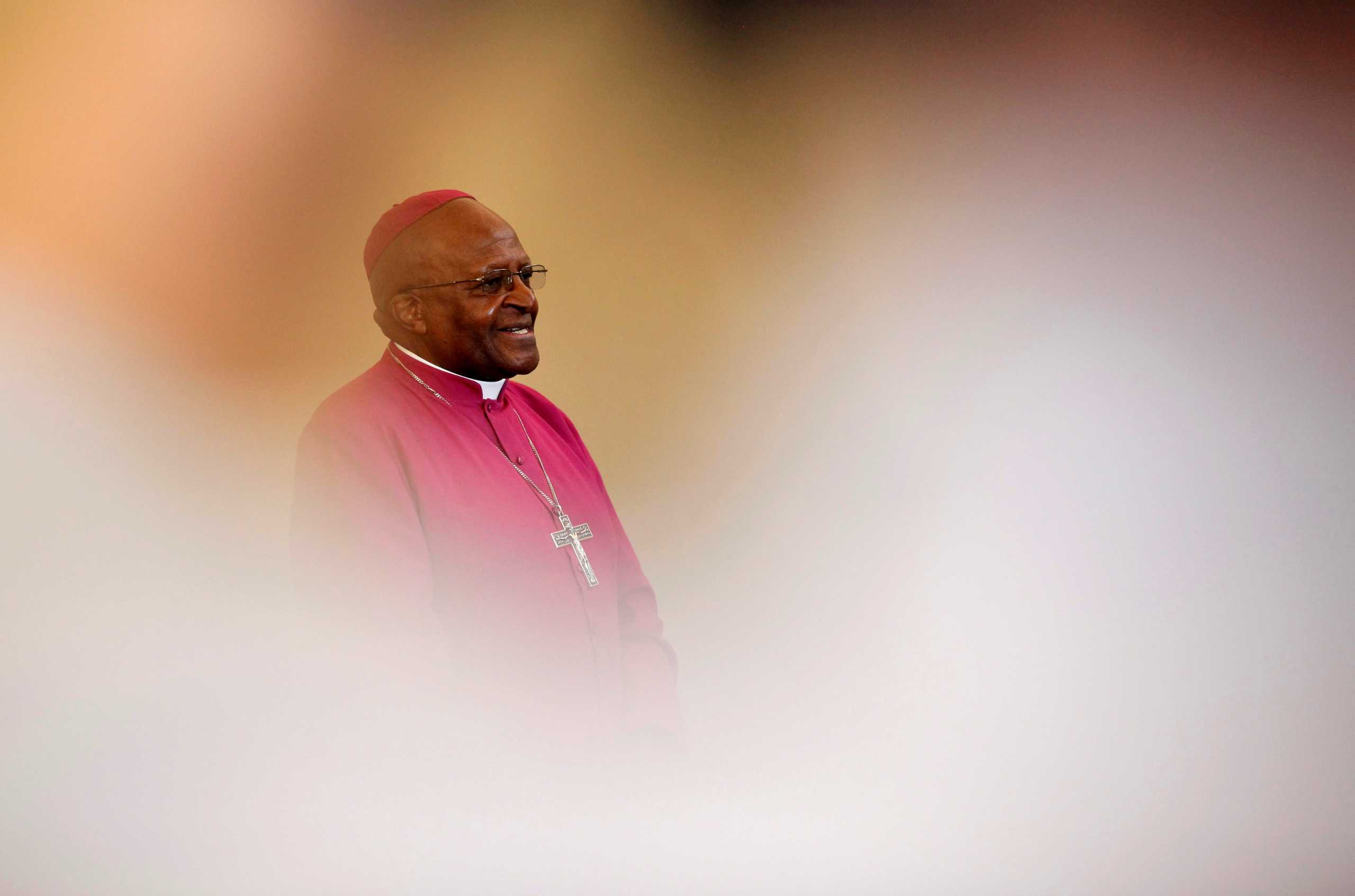 FILE PHOTO: Archbishop Desmond Tutu is seen through crowds during a visit to a youth centre in Masiphelele township near Cape Town, South Africa,  July 8, 2011. REUTERS