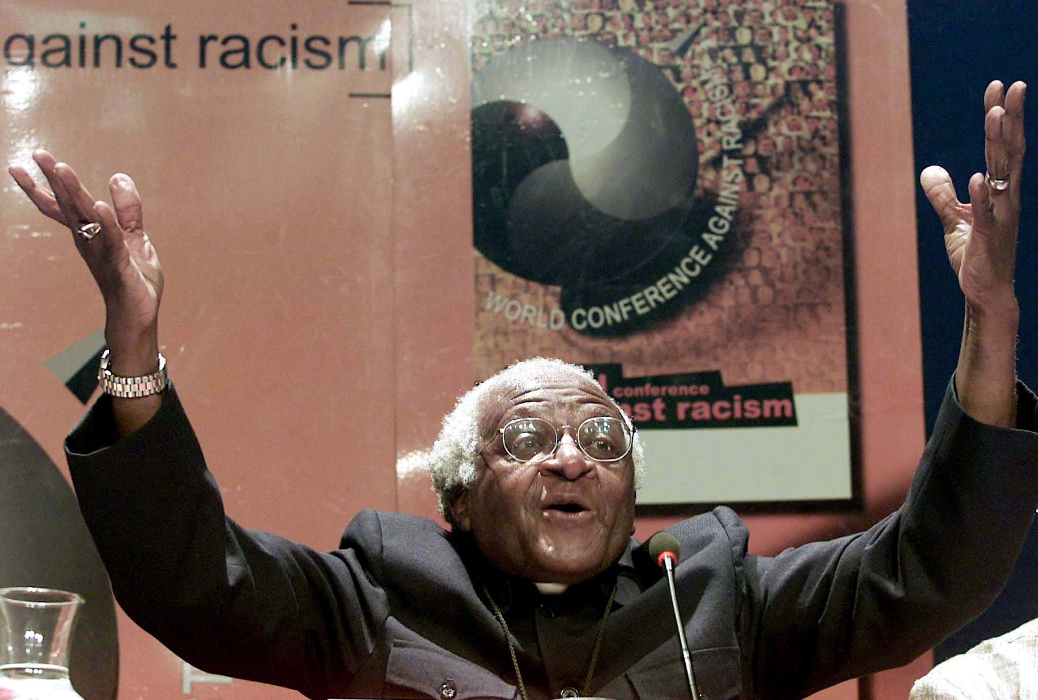 FILE PHOTO: Nobel Peace laureate Archbishop Desmond Tutu gestures as he addresses journalists at the World Conference Against Racism (WCAR), September 5, 2001. Tutu made a call for reparations for slavery saying that they would be like a balm to the wounds of Africa's past. - REUTERS