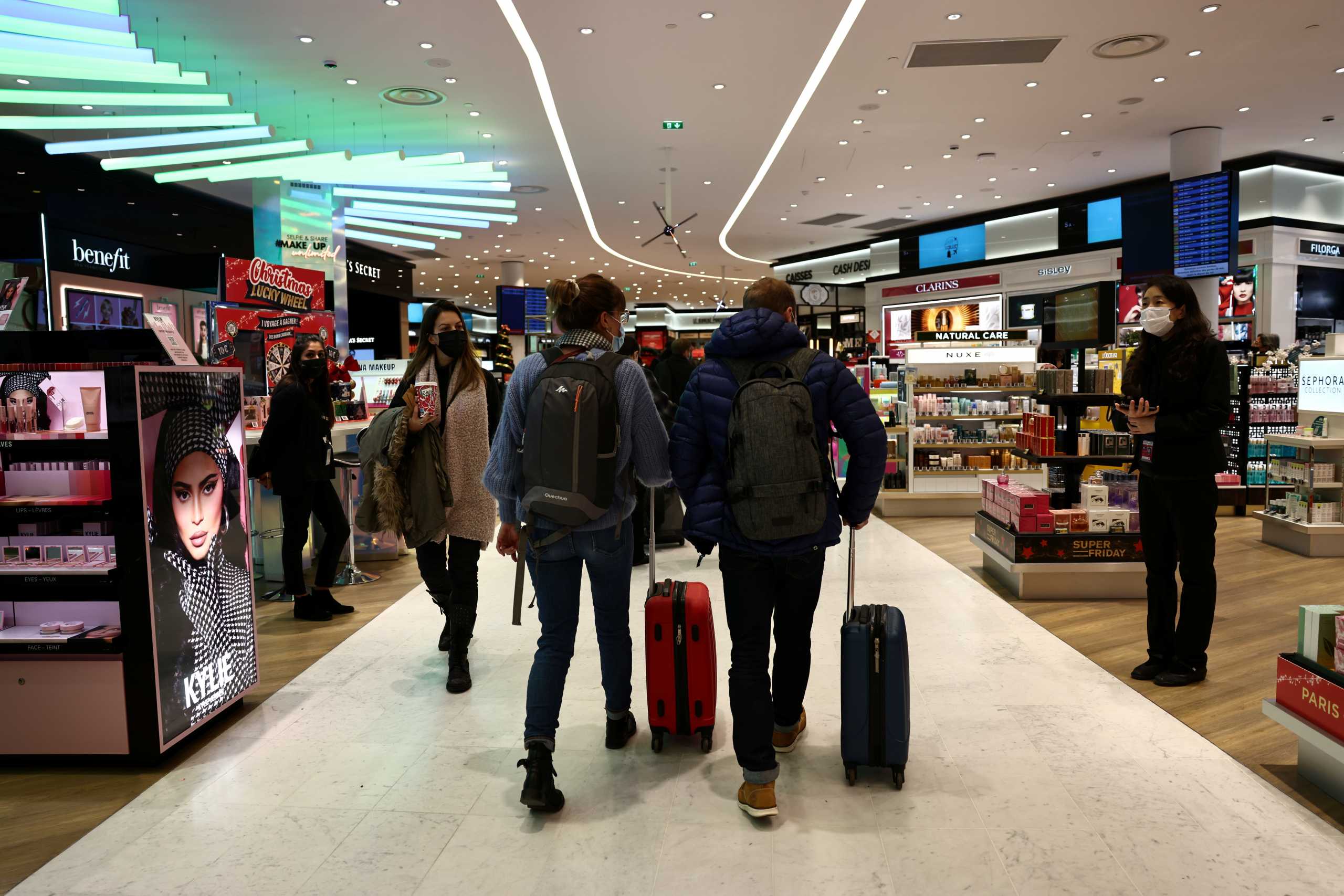 Passengers walk inside a duty free shop at Paris Charles de Gaulle airport in Roissy-en-France near Paris, France, December 2, 2021. REUTERS