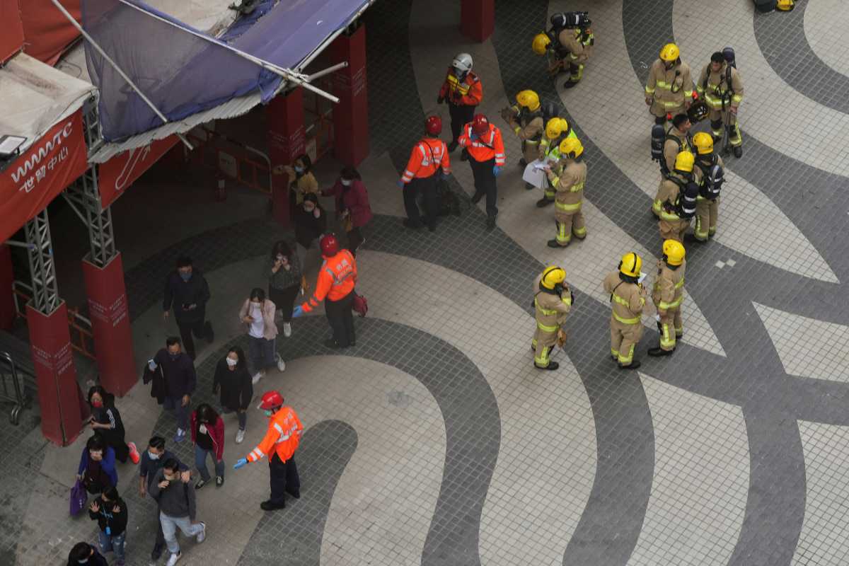 Rescue workers evacuate people from the site after a fire broke out at the World Trade centre in Hong Kong, China, December 15, 2021. REUTERS