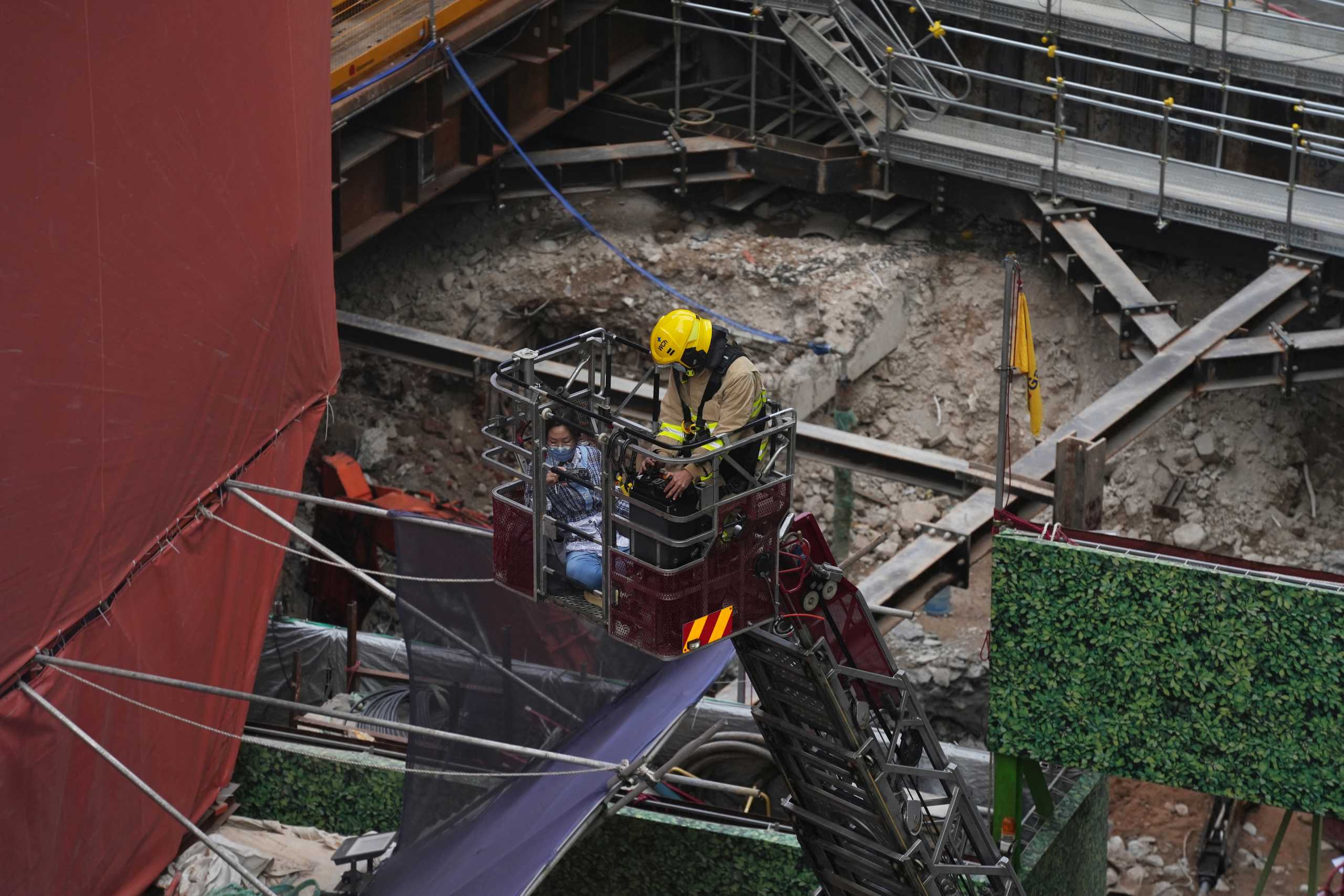 A firefighter rescues a victim trapped in a fire that broke out at the World Trade centre in Hong Kong, China, December 15, 2021. REUTERS