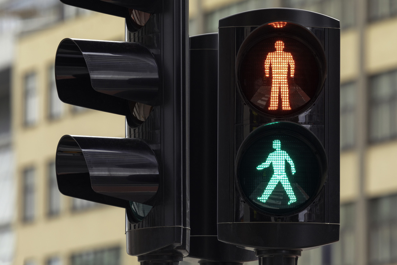 Pedestrian traffic light with both red and green lights illuminated.