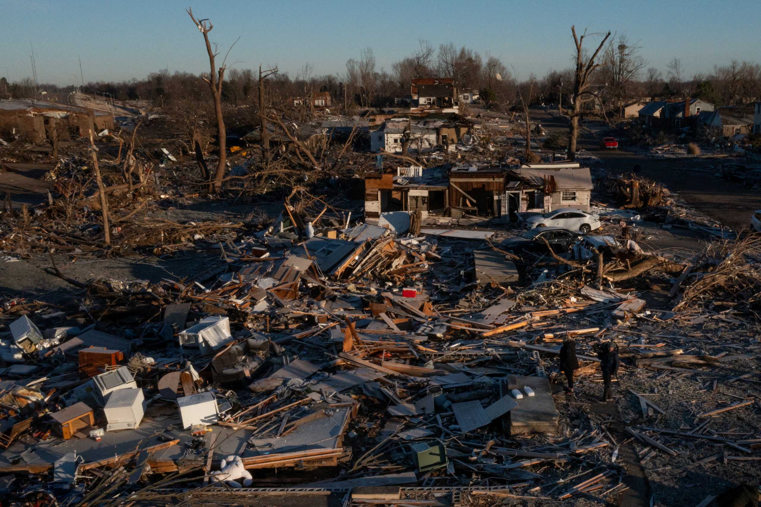 Residents stand in the rubble of a destroyed residence in the aftermath of a tornado in Mayfield, Kentucky, U.S. December 12, 2021. Picture taken with a drone. REUTERS