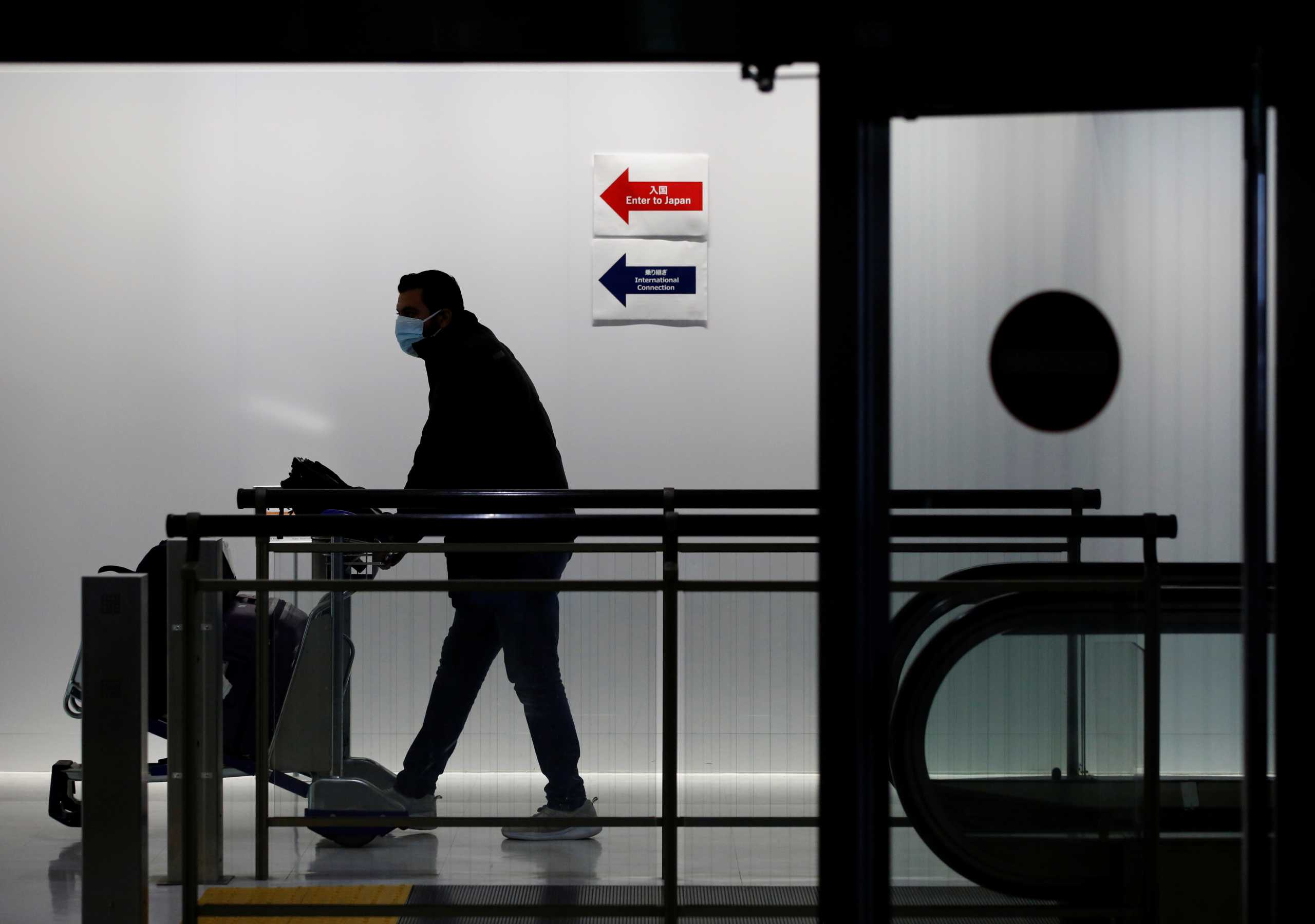 A passenger wearing a protective mask makes his way next to an arrival gate of Narita international airport on the first day of closed borders to prevent the spread of the new coronavirus Omicron variant amid the coronavirus disease (COVID-19) pandemic in Narita, east of Tokyo, Japan, November 30, 2021. REUTERS