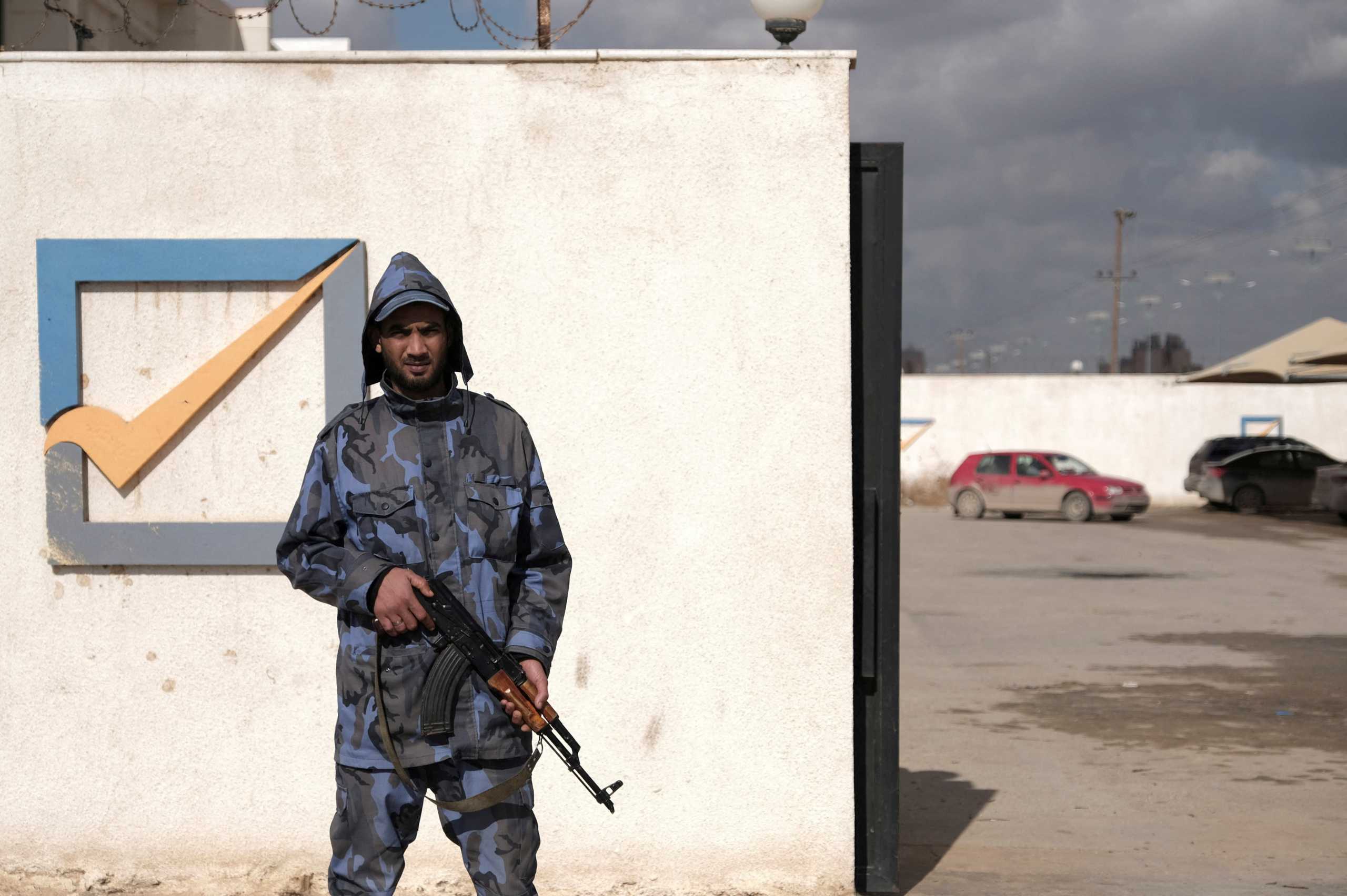 FILE PHOTO: A security officer stands in front of the High National Election Commission building in Benghazi, Libya December 16, 2021. REUTERS