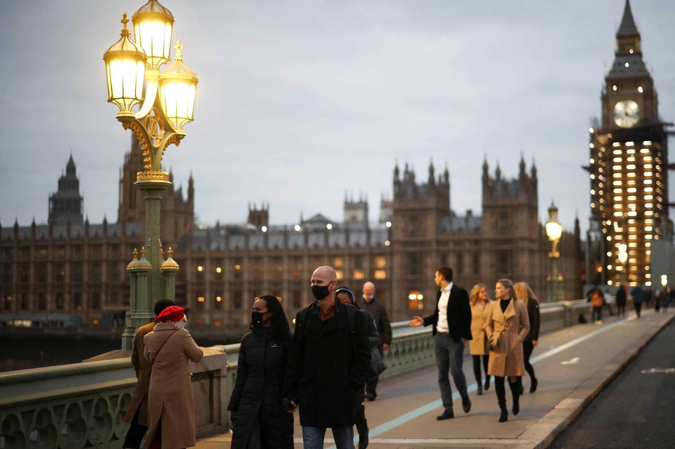 People walk across Westminster Bridge, amid the coronavirus disease (COVID-19) outbreak in London, Britain, December 15, 2021. REUTERS