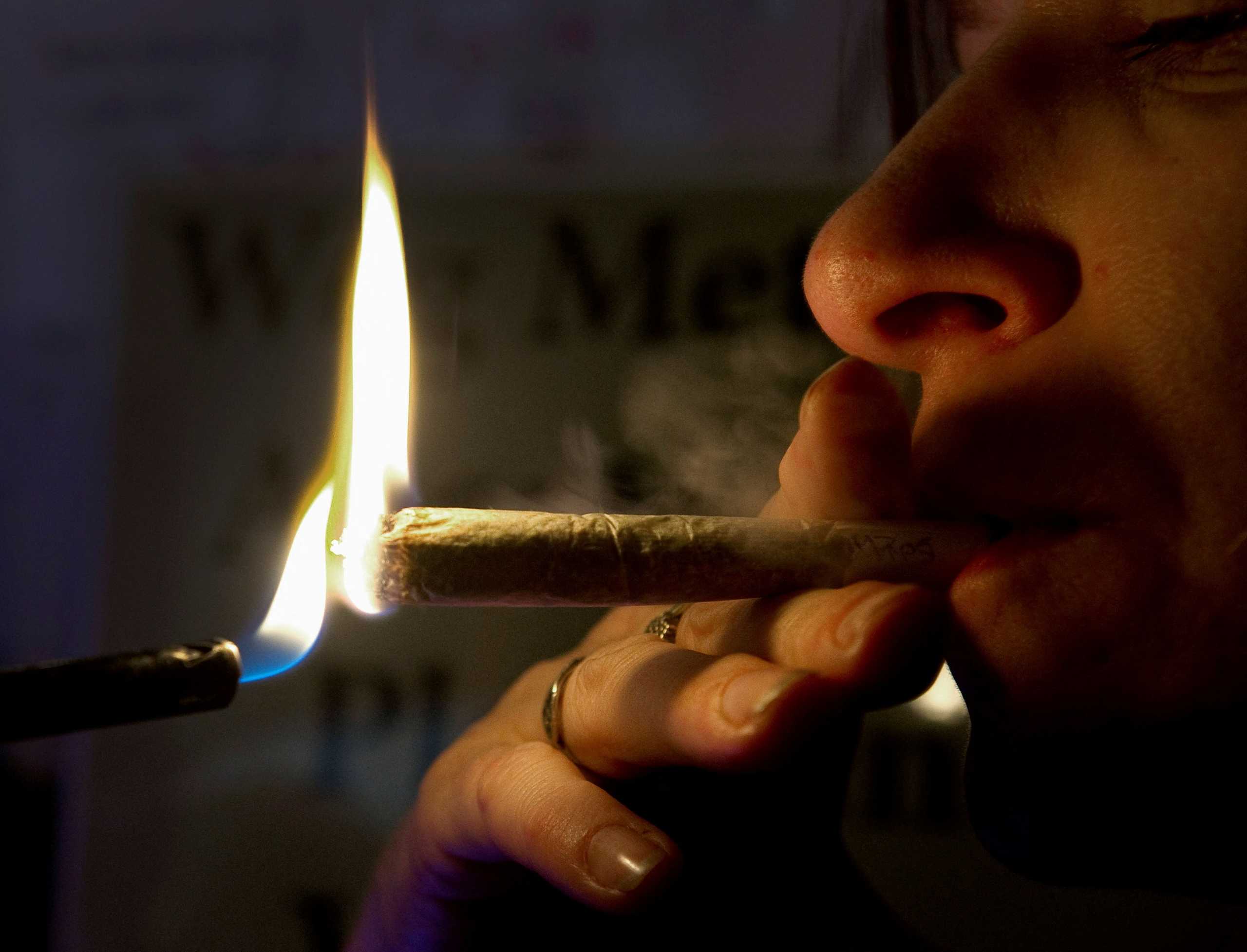 FILE PHOTO: A Dutch woman smokes a cannabis cigarette in a coffee shop in Amsterdam. Picture taken October 6, 2011.  REUTERS
