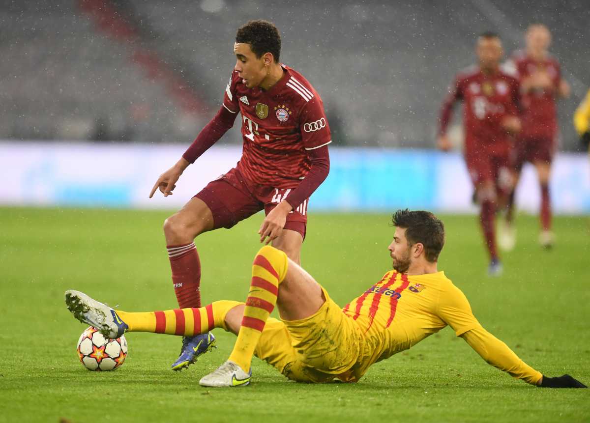 Soccer Football - Champions League - Group E - Bayern Munich v FC Barcelona - Allianz Arena, Munich, Germany - December 8, 2021 Bayern Munich's Jamal Musiala in action with FC Barcelona's Gerard Pique REUTERS