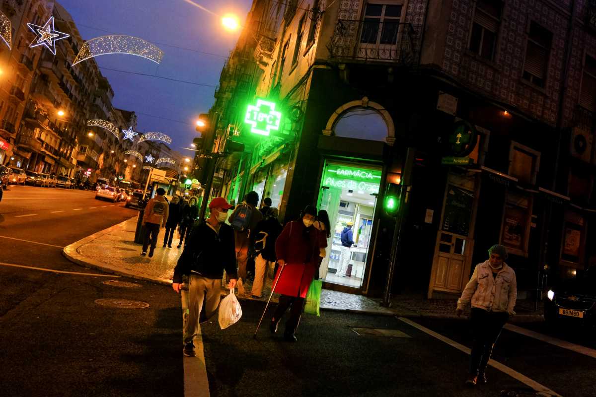 People wearing protective masks walk in Arroios neighborhood amid the coronavirus disease (COVID-19) in Lisbon, Portugal, December 23, 2021. Picture taken December 23, 2021. REUTERS