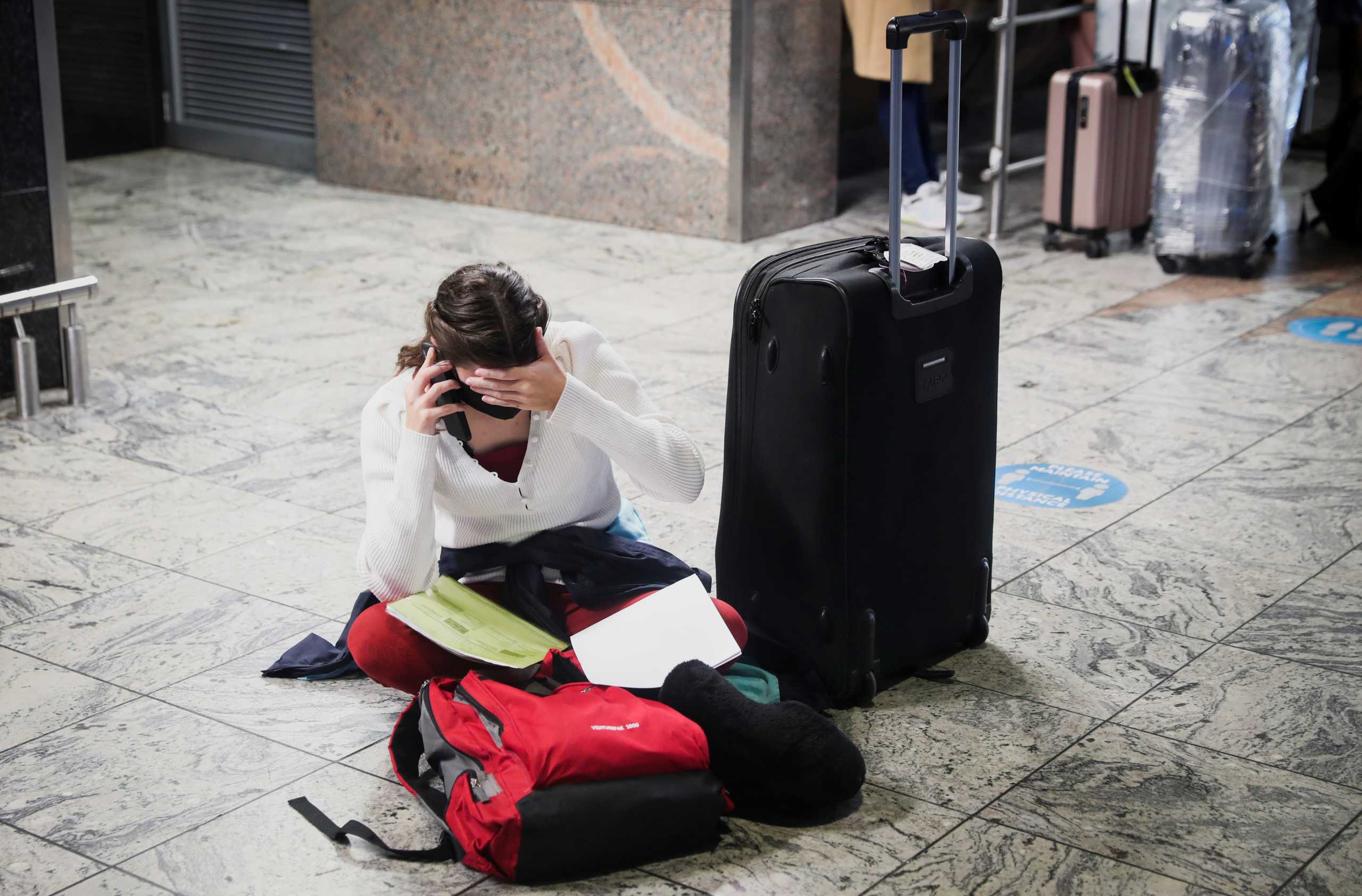 A passenger tries to find a flight as several airlines have stopped flying out of South Africa, amidst the spread of the new SARS-CoV-2 variant Omicron, at O.R. Tambo International Airport in Johannesburg, South Africa, November 28, 2021. REUTERS