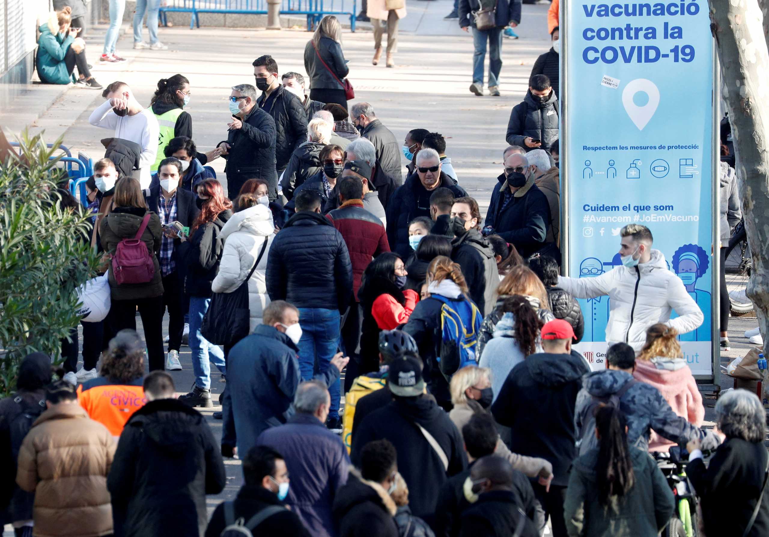 FILE PHOTO: People queue for their doses of the coronavirus disease (COVID-19) vaccine outside a vaccination centre in Barcelona, Spain, December 14, 2021.  REUTERS