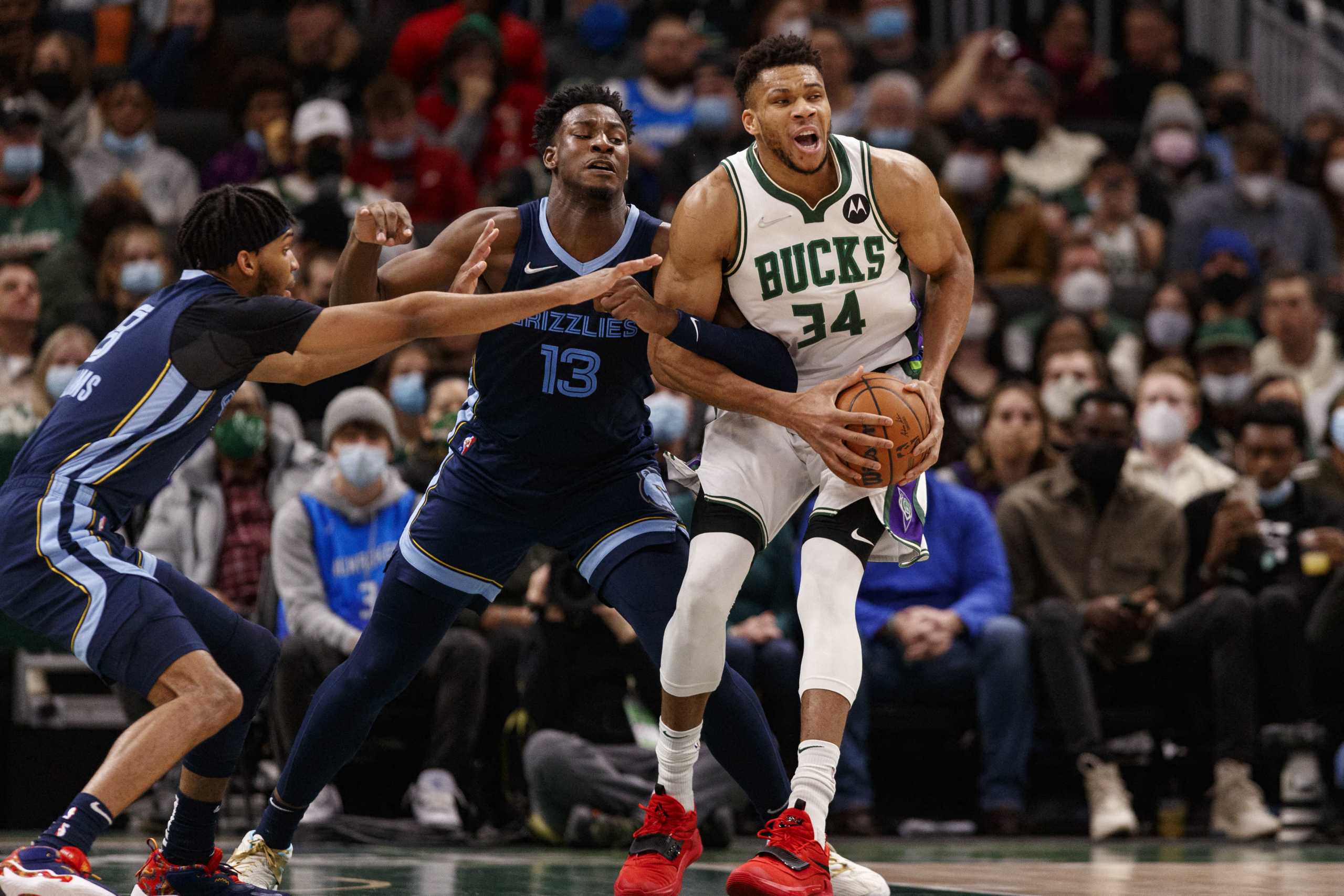 Jan 19, 2022; Milwaukee, Wisconsin, USA;  Milwaukee Bucks forward Giannis Antetokounmpo (34) spins away from pressure from Memphis Grizzlies forwards Ziaire Williams (8) and forward Jaren Jackson Jr. (13) during the first quarter at Fiserv Forum. Mandatory Credit: Jeff Hanisch-USA TODAY Sports