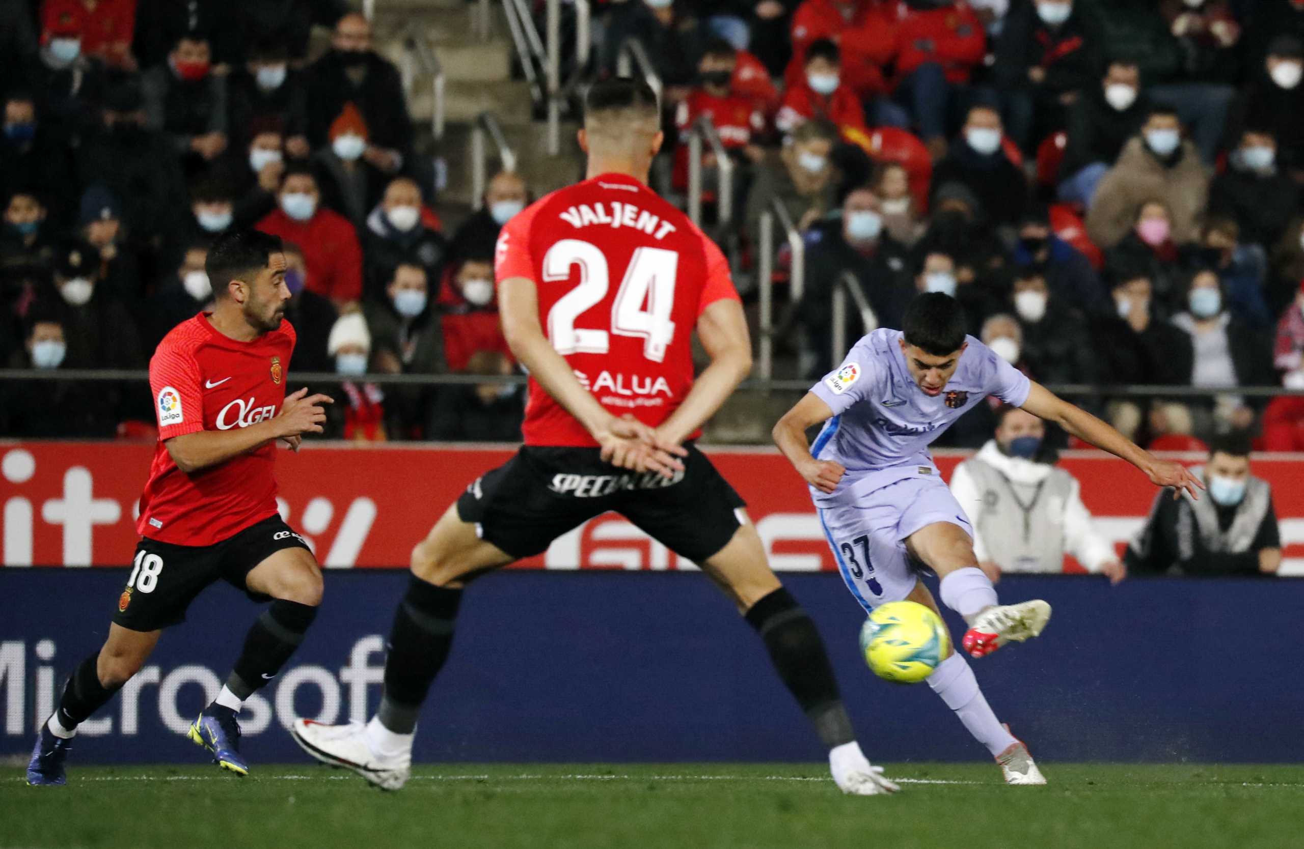 Soccer Football - LaLiga - RCD Mallorca v FC Barcelona - Visit Mallorca Stadium, Palma, Mallorca, Spain - January 2, 2022 FC Barcelona's Ilias Akhomach in action with RCD Mallorca's Jaume Costa and Martin Valjent REUTERS