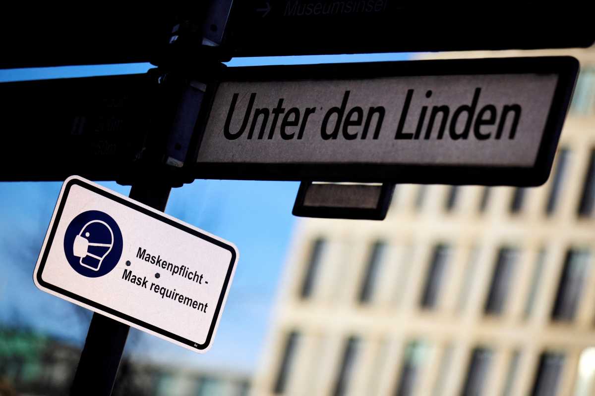 FILE PHOTO: A sign indicates to wear a face mask as the spread of the coronavirus disease (COVID-19) continues at Unter den Linden street in Berlin, Germany, December 18, 2020. REUTERS