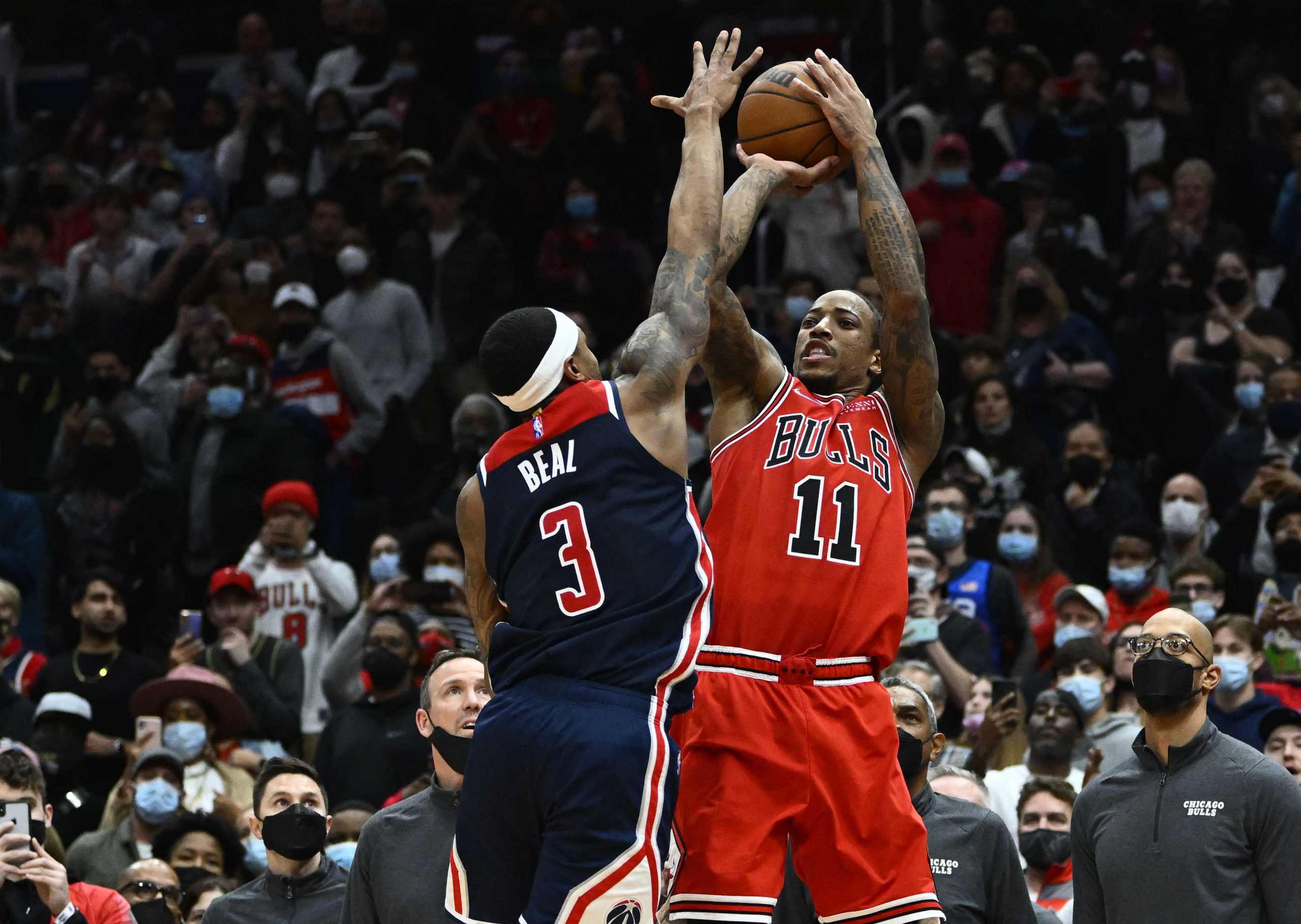 Jan 1, 2022; Washington, District of Columbia, USA; Chicago Bulls forward DeMar DeRozan (11) hits a game winning three point shot over Washington Wizards guard Bradley Beal (3) during the second half at Capital One Arena. Mandatory Credit: Brad Mills-USA TODAY Sports