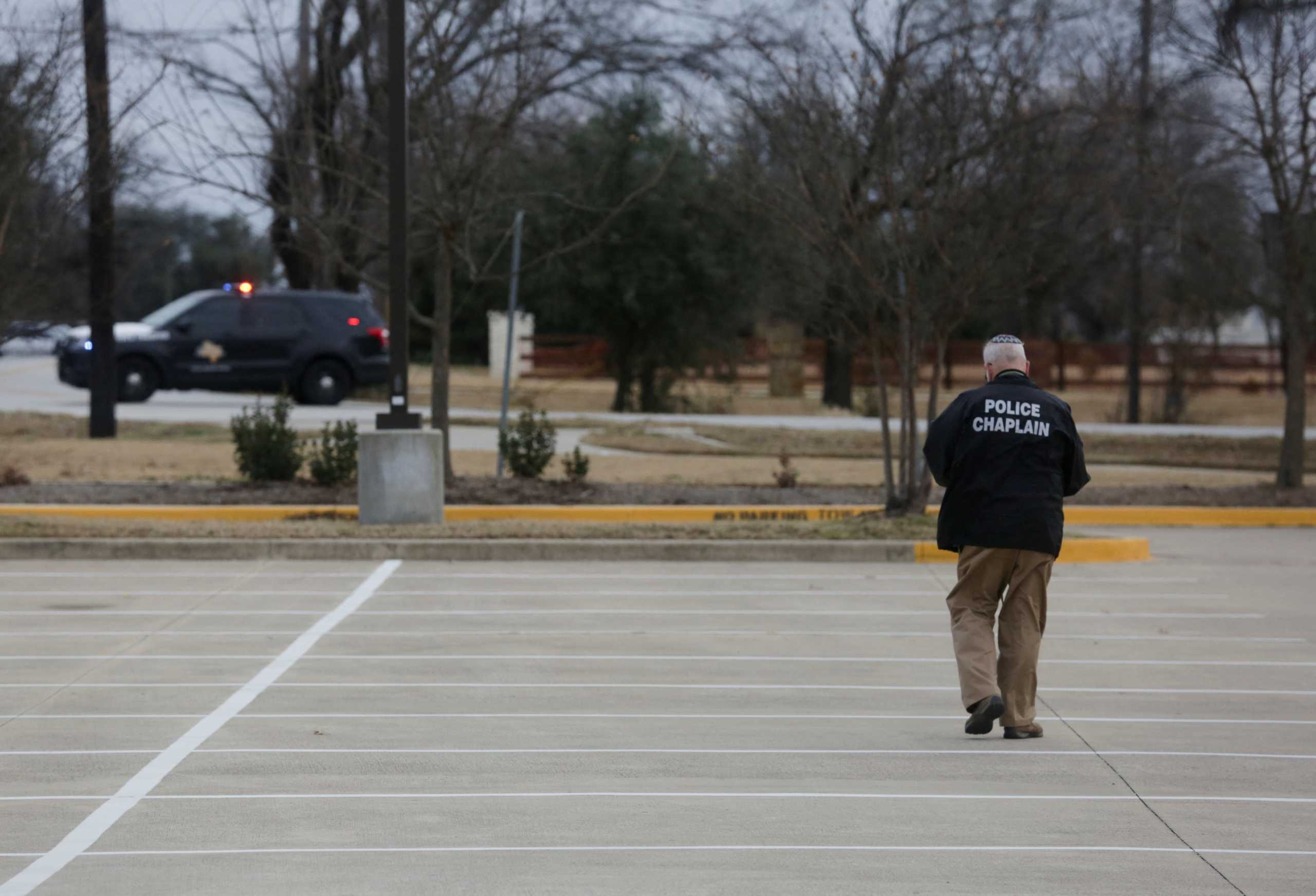 A Police chaplain walks in the area where a man has reportedly taken people hostage at a synagogue during services that were being streamed live, in Colleyville, Texas, U.S. January 15, 2022. REUTERS
