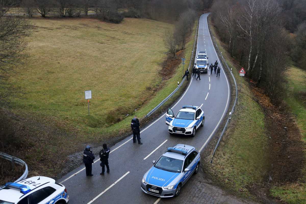 Police officers search the area on a road near the site where two German police officers were fatally shot early January 31, 2022, during a routine traffic stop near Kusel, southwestern Germany, January 31, 2022. REUTERS