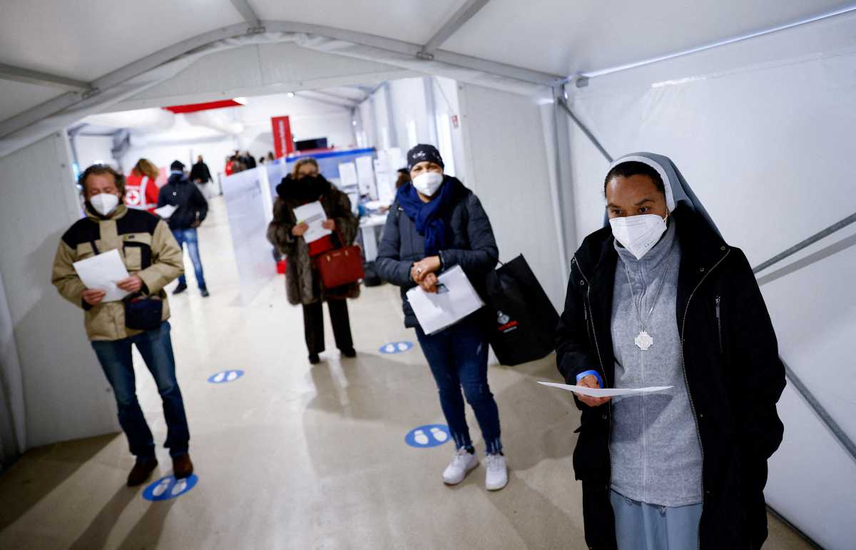 FILE PHOTO: People wait to get a dose of the vaccine against the coronavirus disease (COVID-19), on the day Italy brings in tougher rules for the unvaccinated, at a Red Cross vaccination centre by Termini main train station in Rome, Italy, January 10, 2022. REUTERS