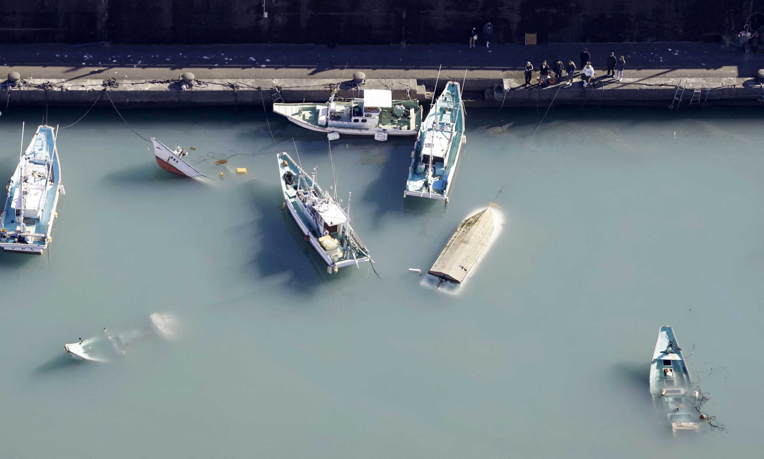 An aerial view shows capsized boats believed to be affected by the tsunami caused by an underwater volcano eruption on the island of Tonga at the South Pacific, in Muroto, Kochi prefecture, Japan, in this photo taken by Kyodo January 16, 2022.  Mandatory credit Kyodo