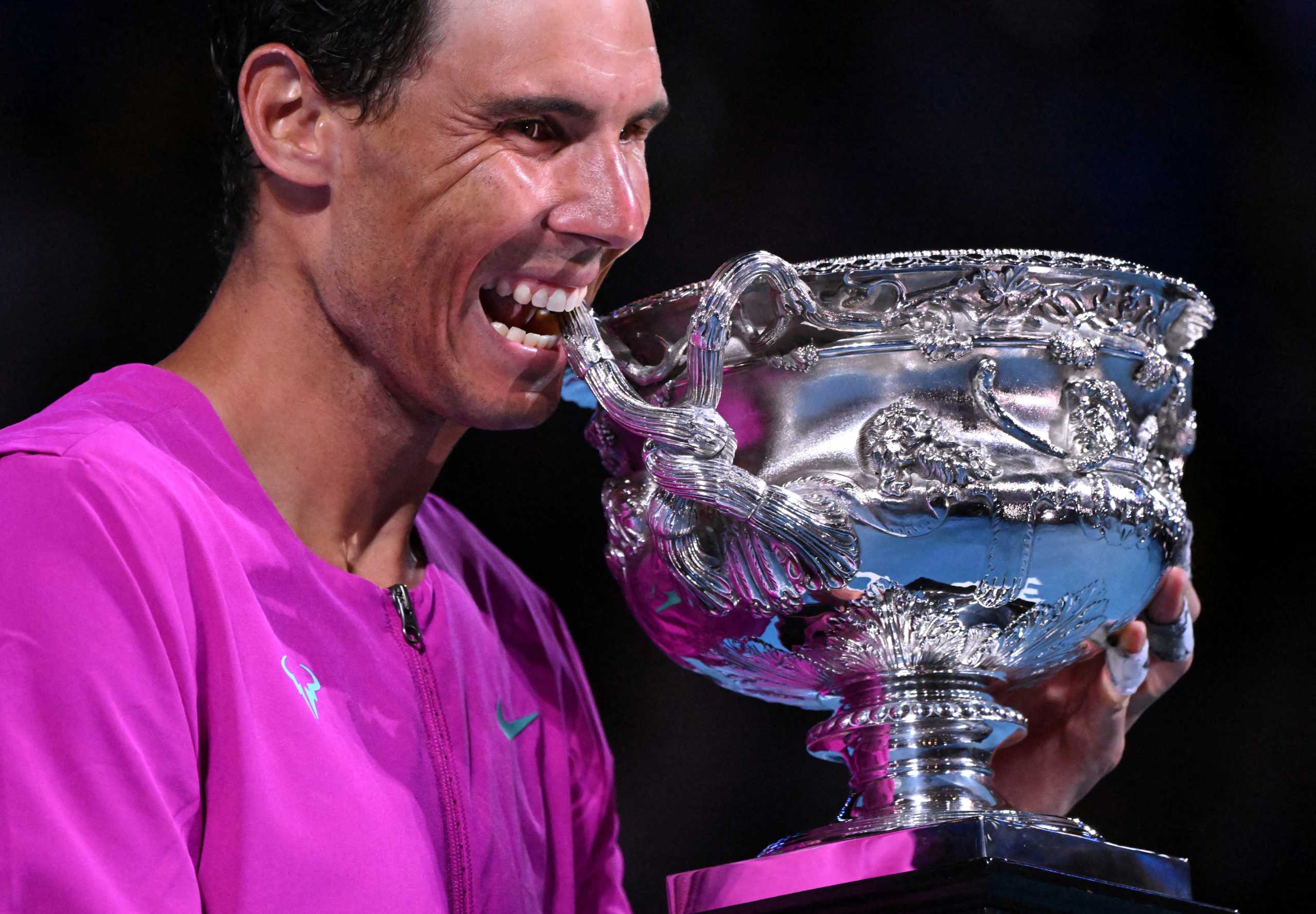 Tennis - Australian Open - Men's Singles Final - Melbourne Park, Melbourne, Australia - January 31, 2022 Spain's Rafael Nadal bites the trophy to celebrate winning the men's singles final REUTERS