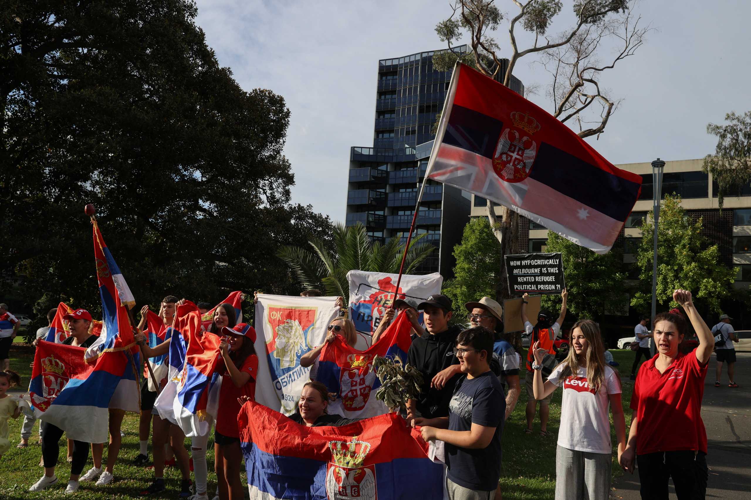 Supporters of Serbian tennis player Novak Djokovic rally outside the Park Hotel, where the star athlete is believed to be held while he stays in Australia, in Melbourne, Australia, January 6, 2022.  REUTERS
