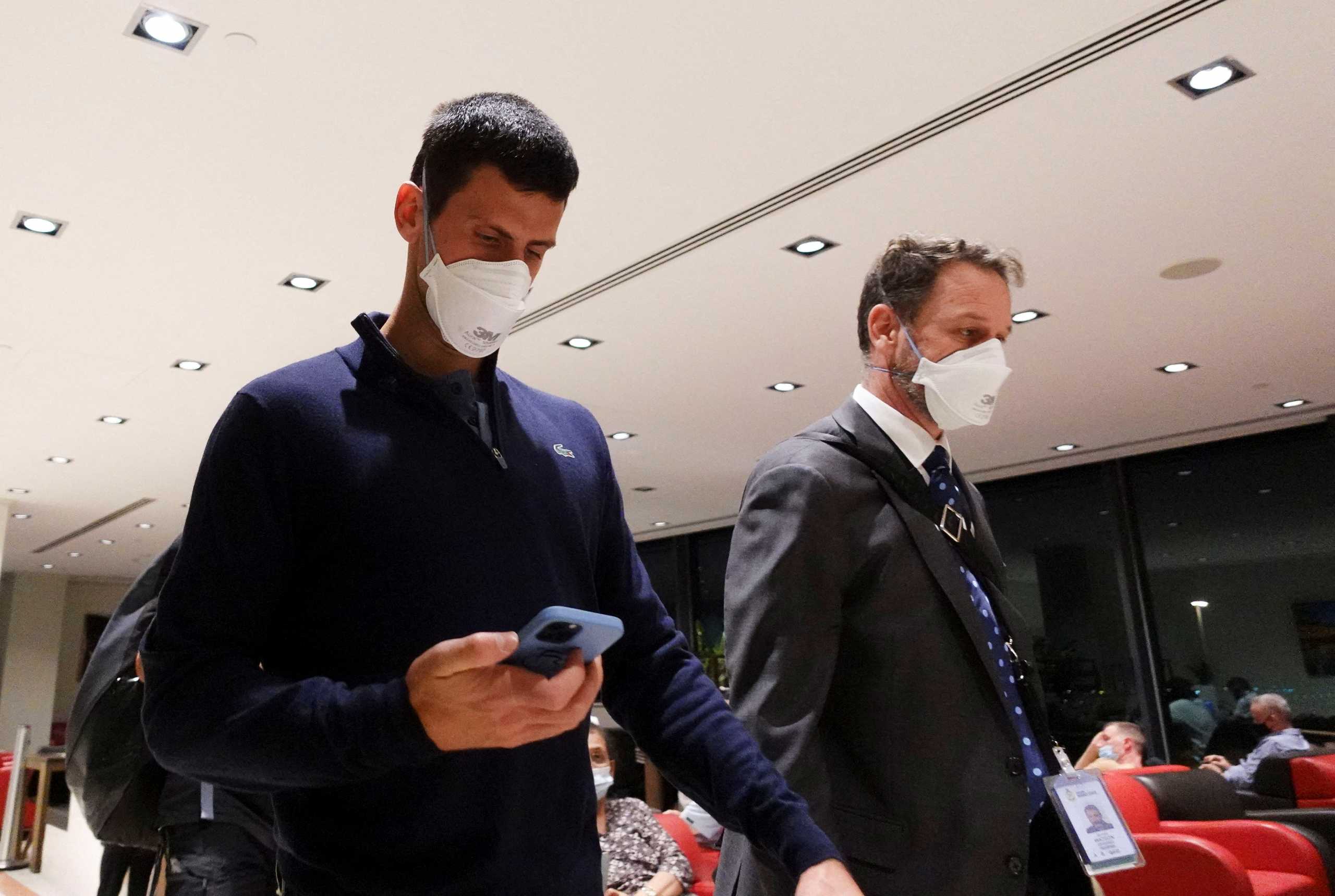 Serbian tennis player Novak Djokovic walks in Melbourne Airport before boarding a flight, after the Federal Court upheld a government decision to cancel his visa to play in the Australian Open, in Melbourne, Australia, January 16, 2022. REUTERS
