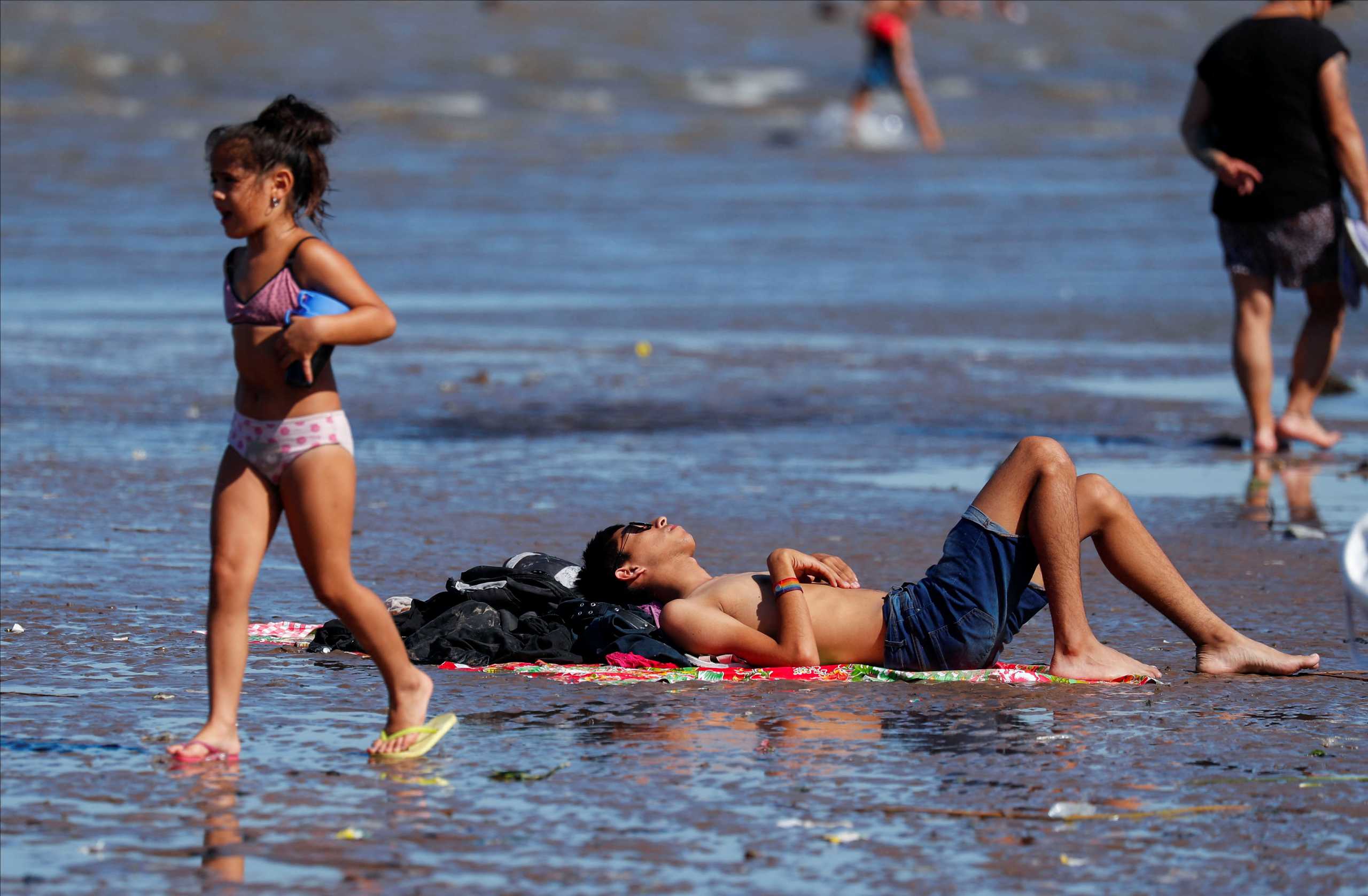 People enjoy the day in the Rio de la Plata river during a heat wave amid a spike of the coronavirus disease (COVID-19) cases, in Buenos Aires, Argentina January 9, 2022. REUTERS