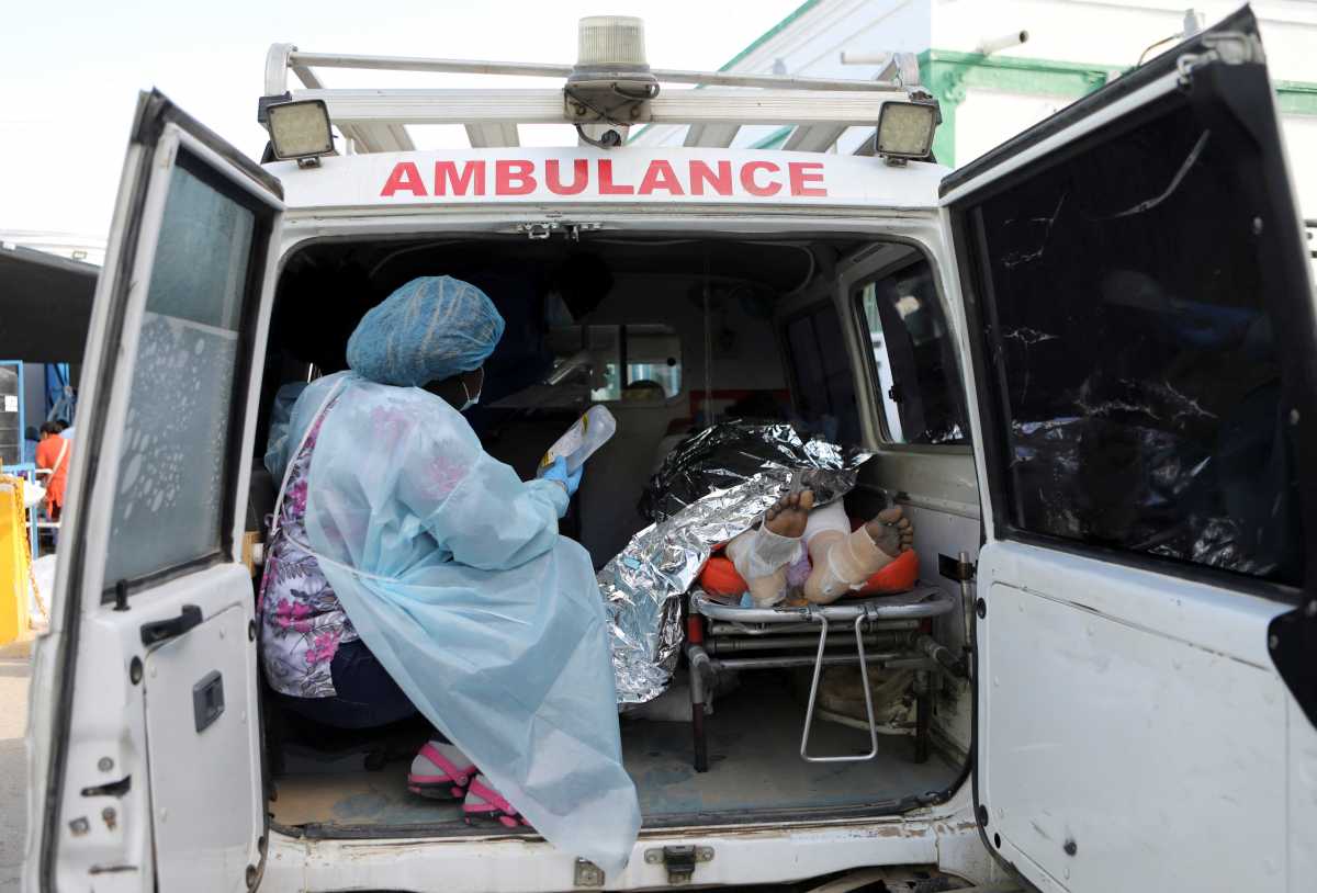 A nurse holds a drip next to a person injured when a fuel truck exploded in a neighbourhood during the night, in Cap Haitien, Haiti December 14, 2021.  REUTERS