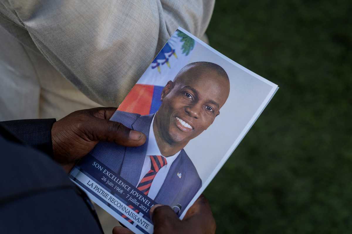 FILE PHOTO: A person holds a photo of late Haitian President Jovenel Moise, who was shot dead earlier this month, during his funeral at his family home in Cap-Haitien, Haiti, July 23, 2021. REUTERS
