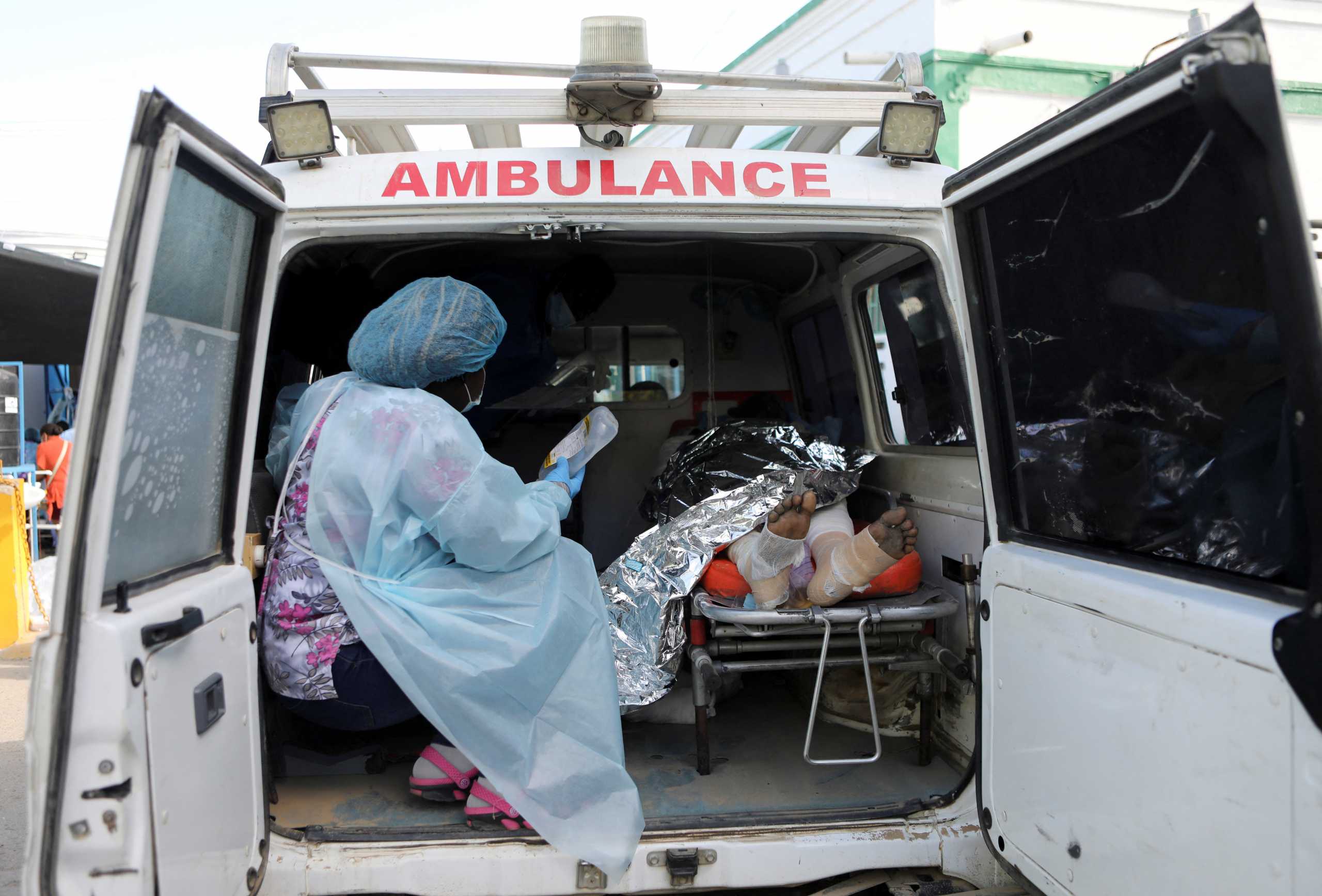 A nurse holds a drip next to a person injured when a fuel truck exploded in a neighbourhood during the night, in Cap Haitien, Haiti December 14, 2021.  REUTERS