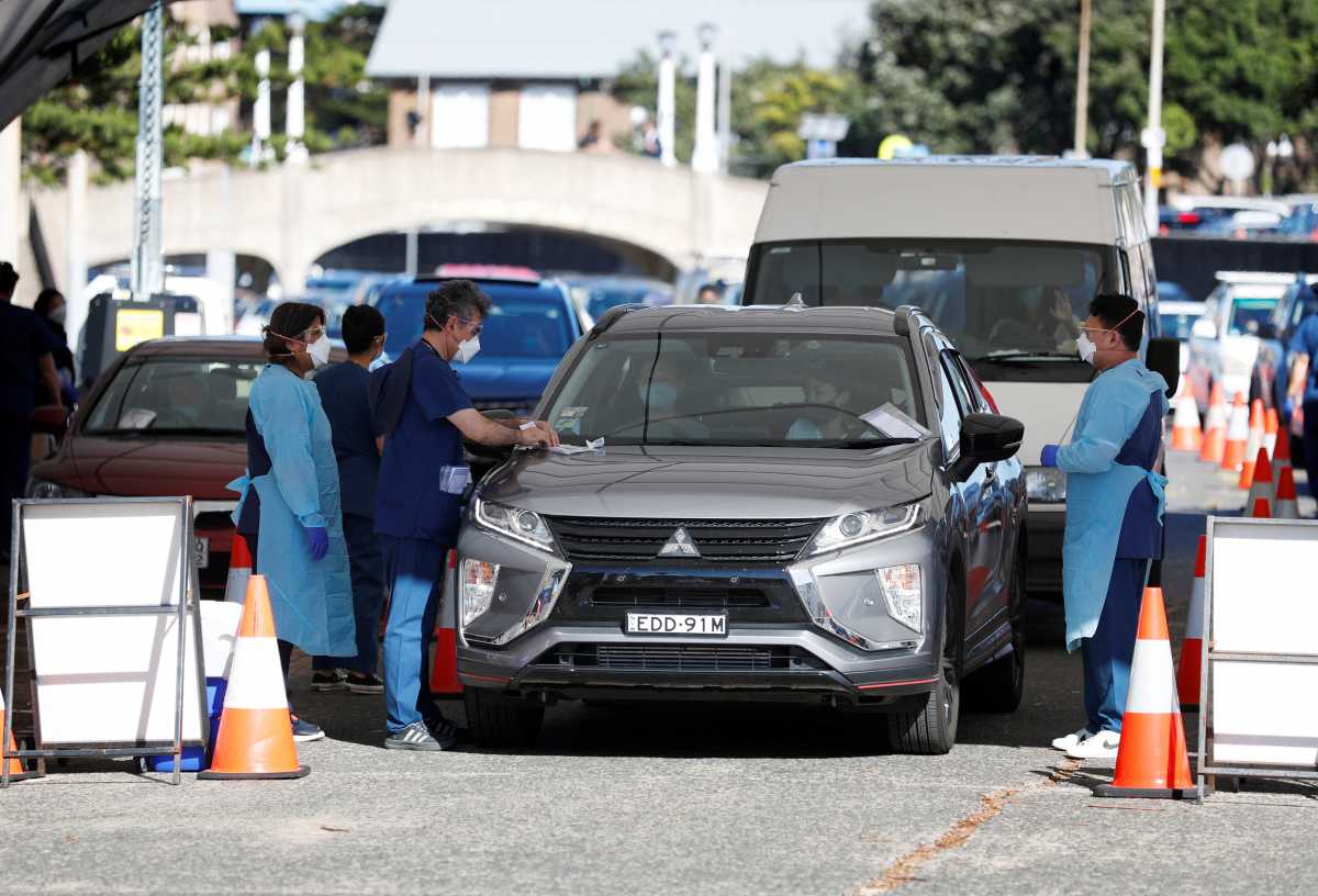 Healthcare workers administer tests at a coronavirus disease (COVID-19) testing clinic as the Omicron coronavirus variant continues to spread in Sydney, Australia, December 30, 2021.  REUTERS