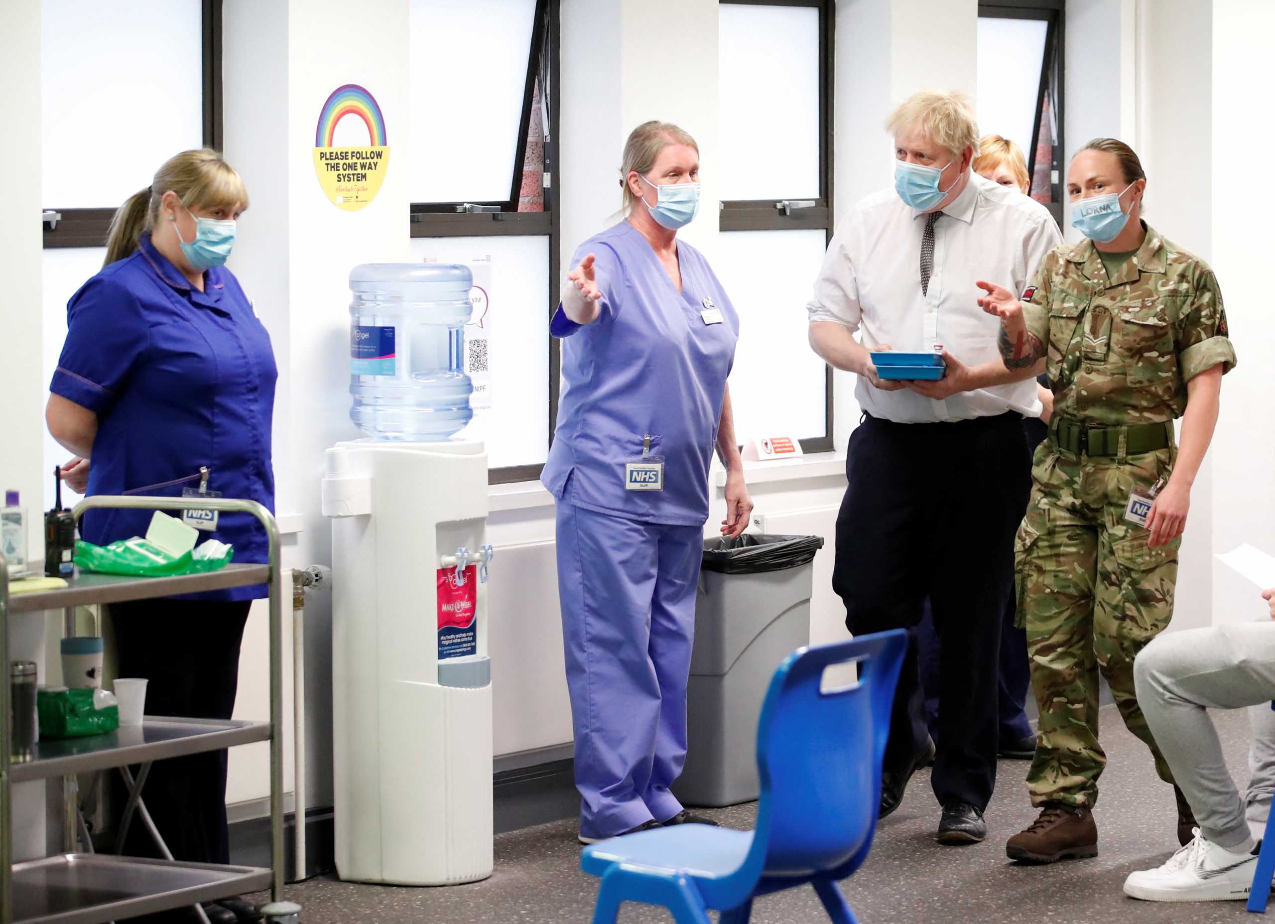 Britain's Prime Minister Boris Johnson walks with corporal Lorna MacDonald during a visit to a coronavirus disease (COVID-19) vaccine centre in Northampton, Britain, January 6, 2022.  REUTERS