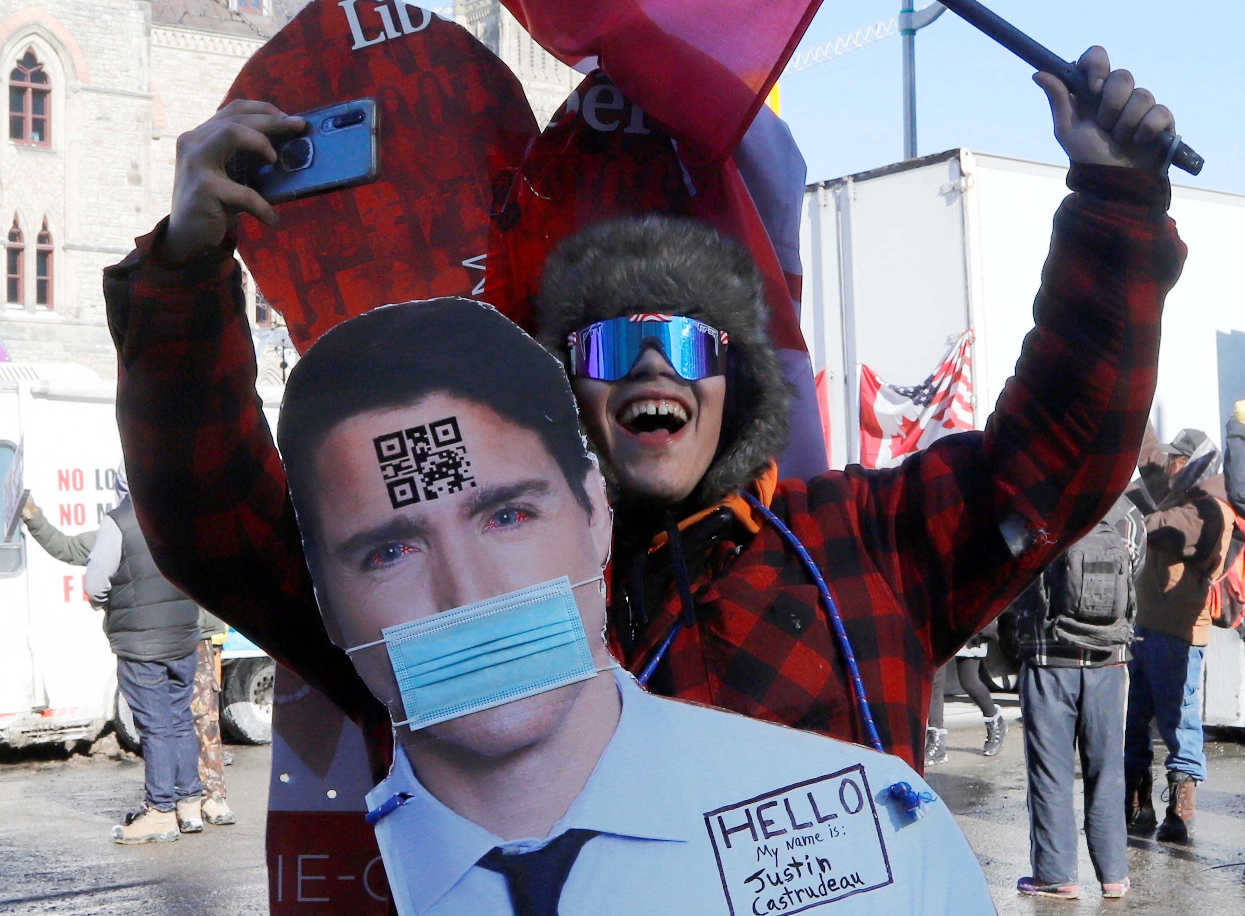 A protestor wears a cutout image of Canada's Prime Minister Justin Trudeau as truckers take part in a convoy to protest coronavirus disease (COVID-19) vaccine mandates for cross-border truck drivers in Ottawa, Ontario, Canada, January 29, 2022. REUTERS