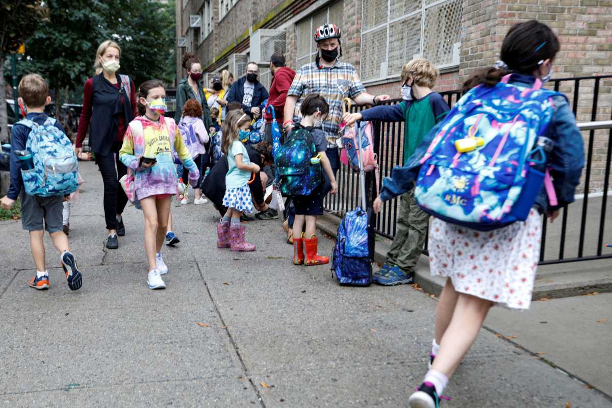 FILE PHOTO: Children arrive at school, amid the coronavirus disease (COVID-19) pandemic in Brooklyn, New York, U.S.  October 4, 2021.  REUTERS