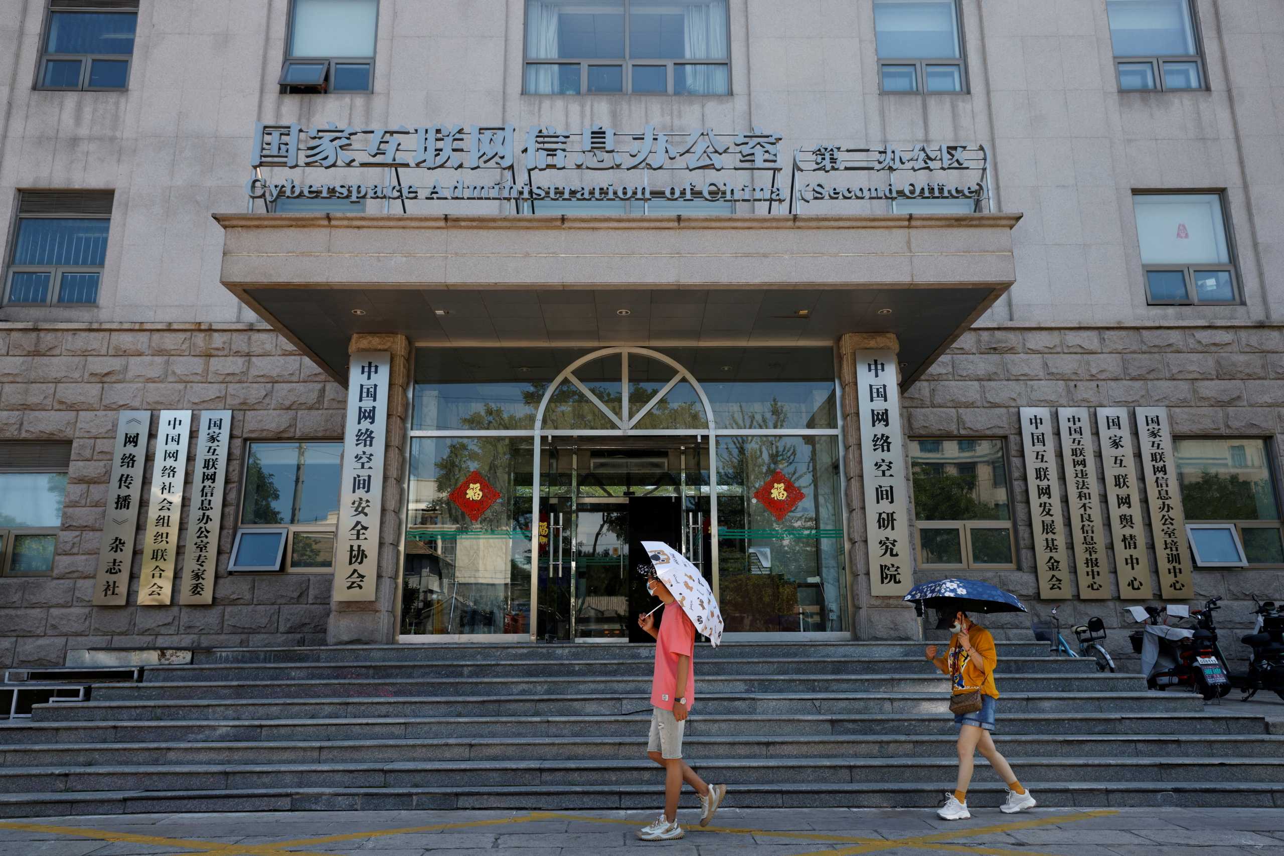 FILE PHOTO: People walk past an office of the Cyberspace Administration of China (CAC) in Beijing, China July 8, 2021. REUTERS