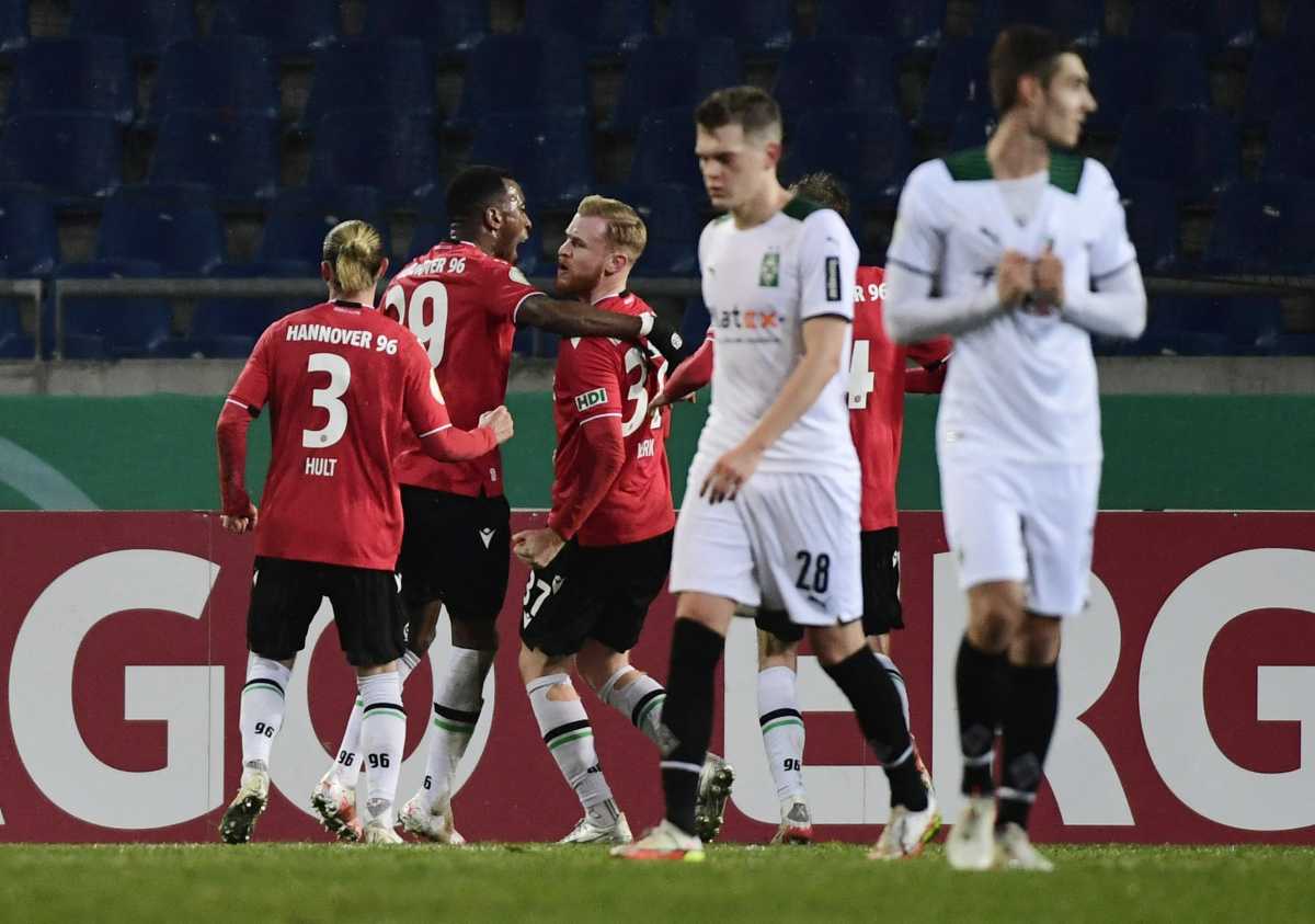 Soccer Football - DFB Cup - Round of 16 - Hannover 96 v Borussia Moenchengladbach - HDI-Arena, Hannover, Germany - January 19, 2022 Hannover 96's Sebastian Kerk celebrates scoring their second goal from the penalty spot with Niklas Hult and Gael Ondoua REUTERS