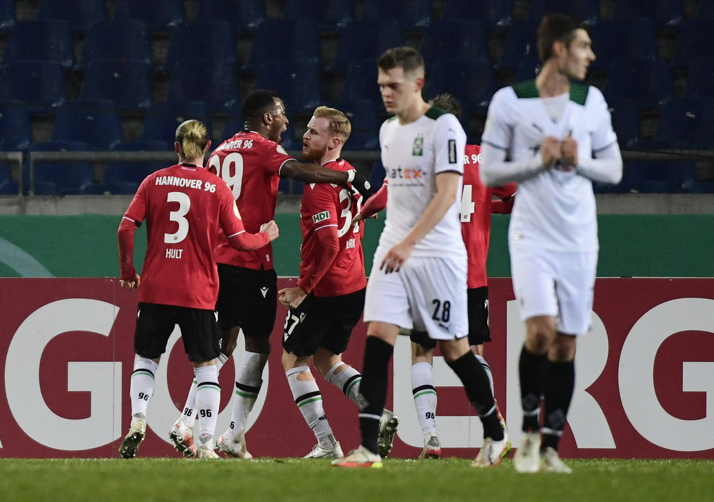 Soccer Football - DFB Cup - Round of 16 - Hannover 96 v Borussia Moenchengladbach - HDI-Arena, Hannover, Germany - January 19, 2022 Hannover 96's Sebastian Kerk celebrates scoring their second goal from the penalty spot with Niklas Hult and Gael Ondoua REUTERS