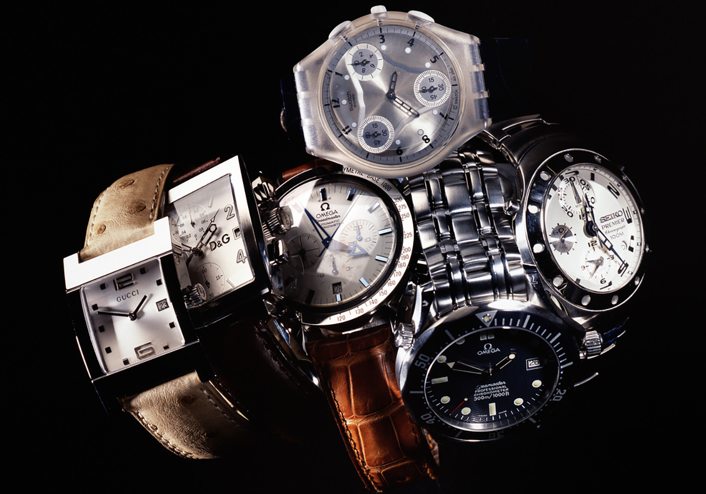 Leiden, The Netherlands - June 26, 2008: Product shot of a Gucci, Omega, Swatch, Seiko, Dolce & Gabbana wristwatch with leather and metal straps, shot in studio on black background.
