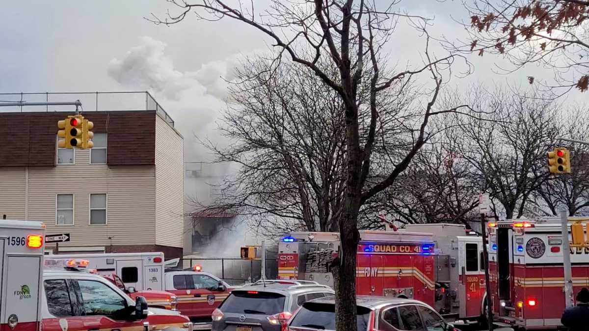 Emergency vehicles line the street as smoke raises following a fire and explosion at a building in New York City, New York, U.S., January 18, 2022, in this still image obtained from social media video. Courtesy of Hector Rodriguez