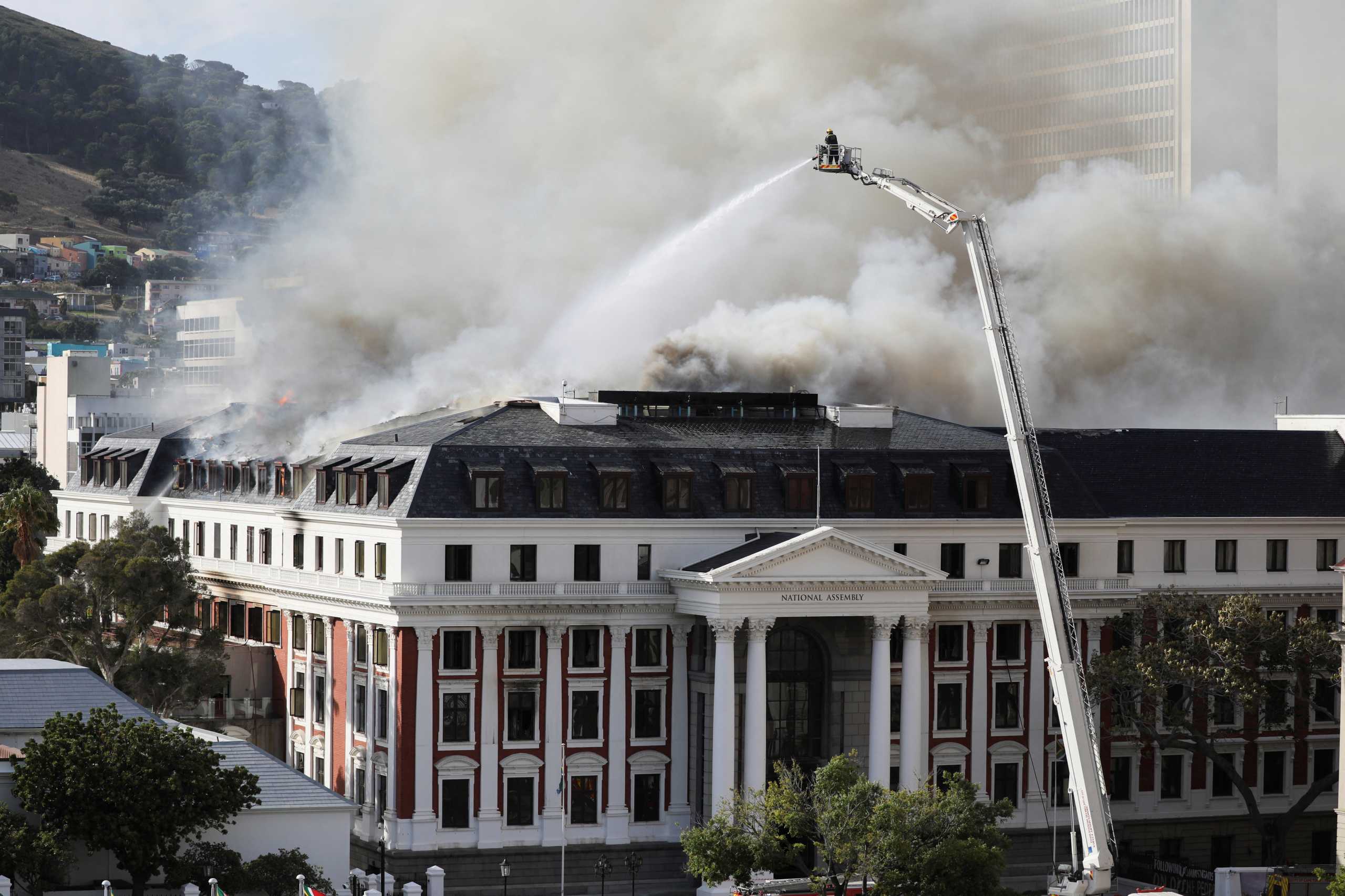 Firefighters work at the parliament as the fire flared up again, in Cape Town, South Africa, January 3, 2022. REUTERS