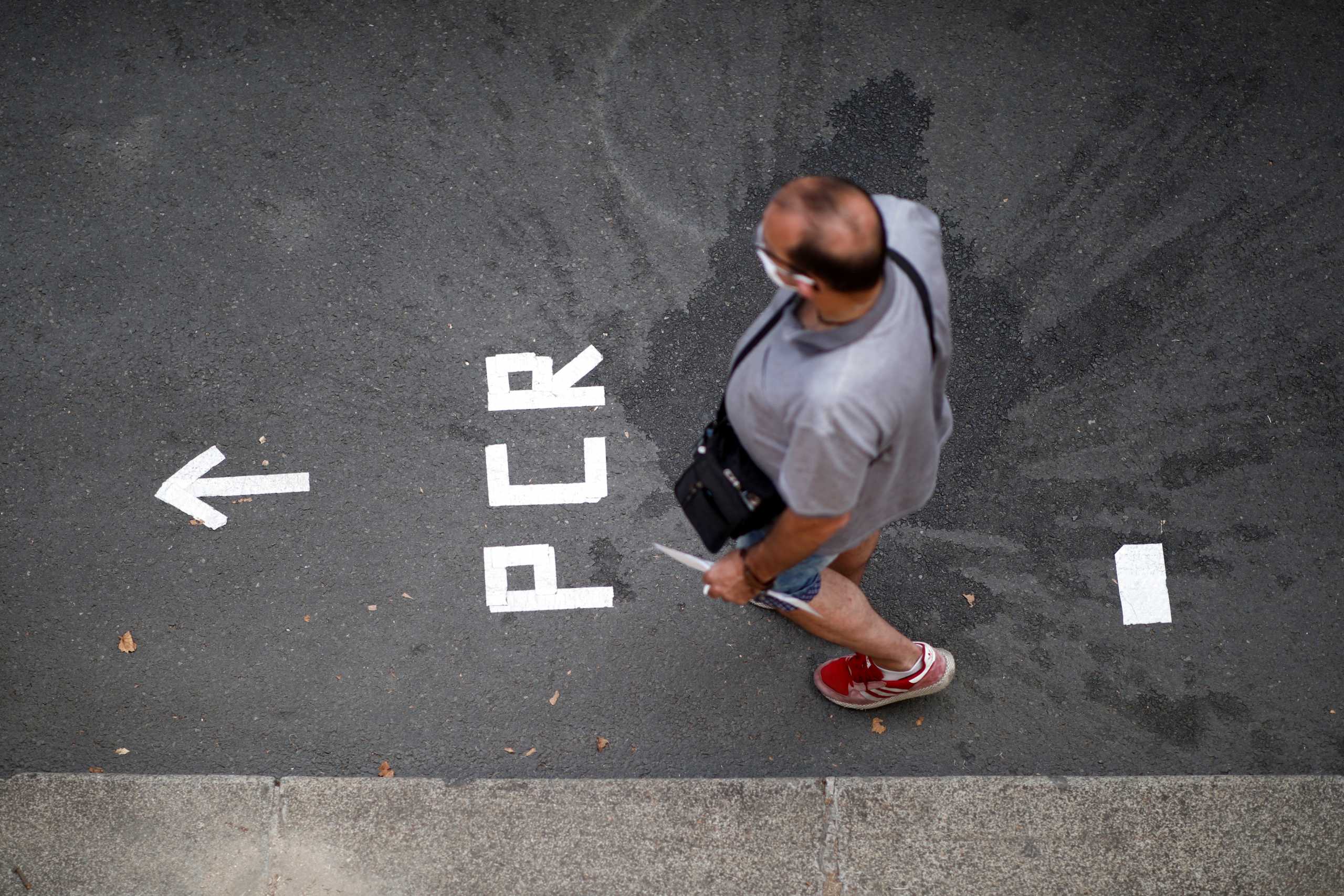 FILE PHOTO: A man queues to take a PCR test for the coronavirus disease (COVID-19) in Paris, France, August 8, 2020. REUTERS