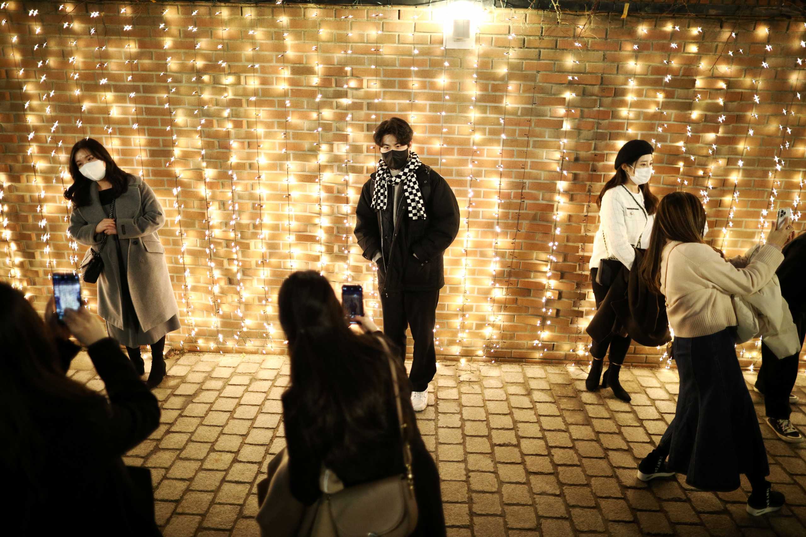People wearing masks to prevent contracting the coronavirus disease (COVID-19) enjoy a Christmas illumination at Myeongdong Cathedral in Seoul, South Korea, December 23, 2021.    REUTERS
